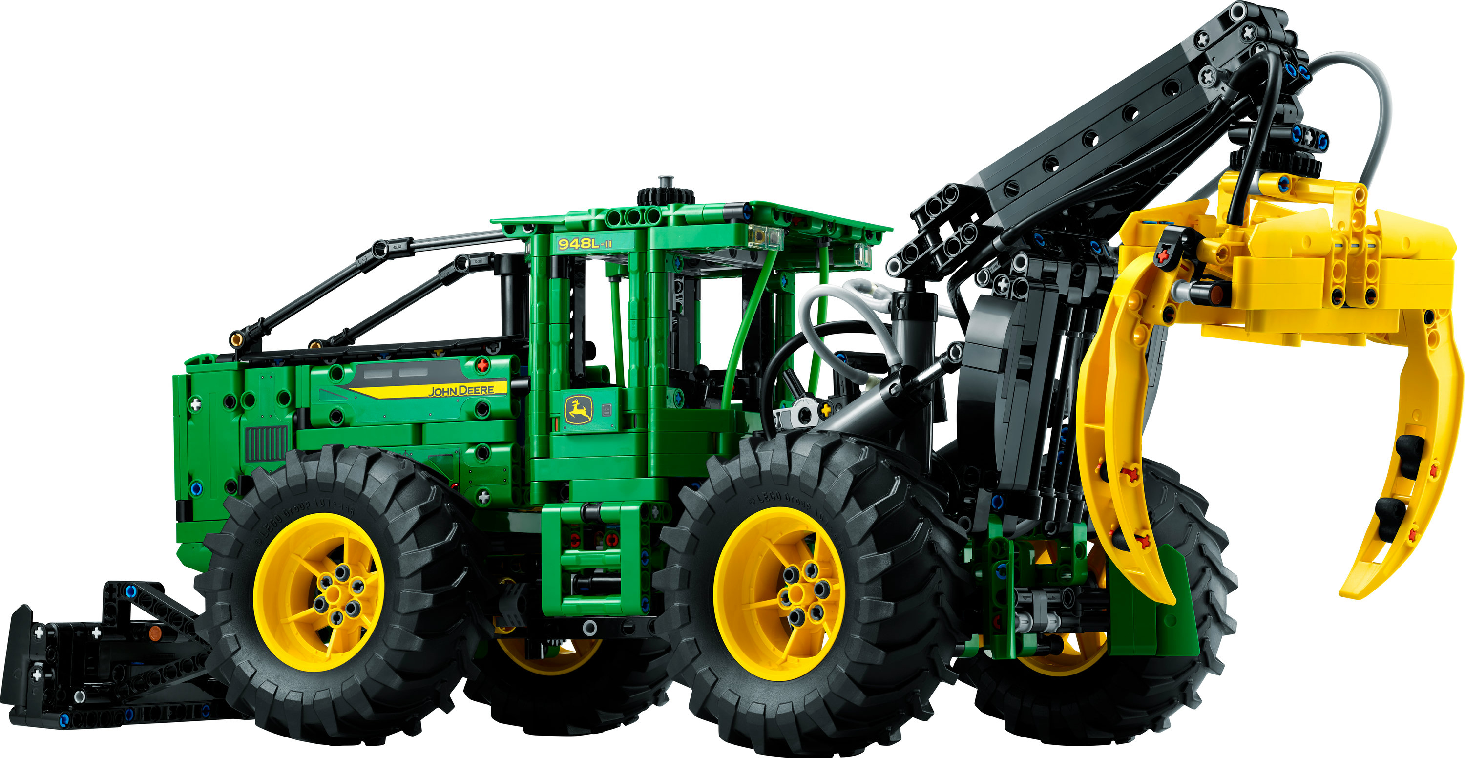 Traktor Lego John Deere z czarnym ramieniem dźwigu i żółtym chwytakiem na końcu.