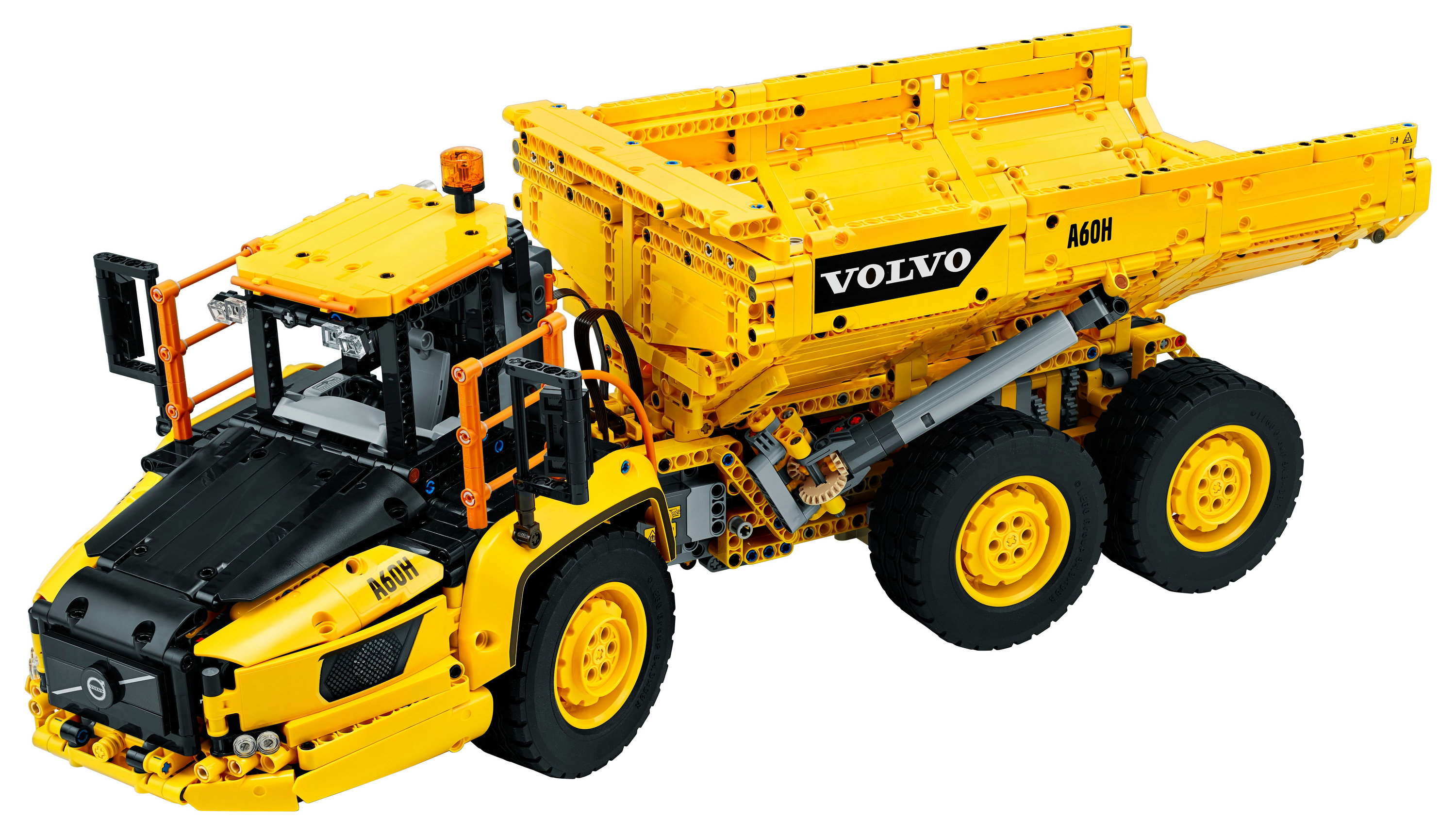 Modello di camion Volvo LEGO giallo. Ruote grandi e design articolato. Sfondo bianco.