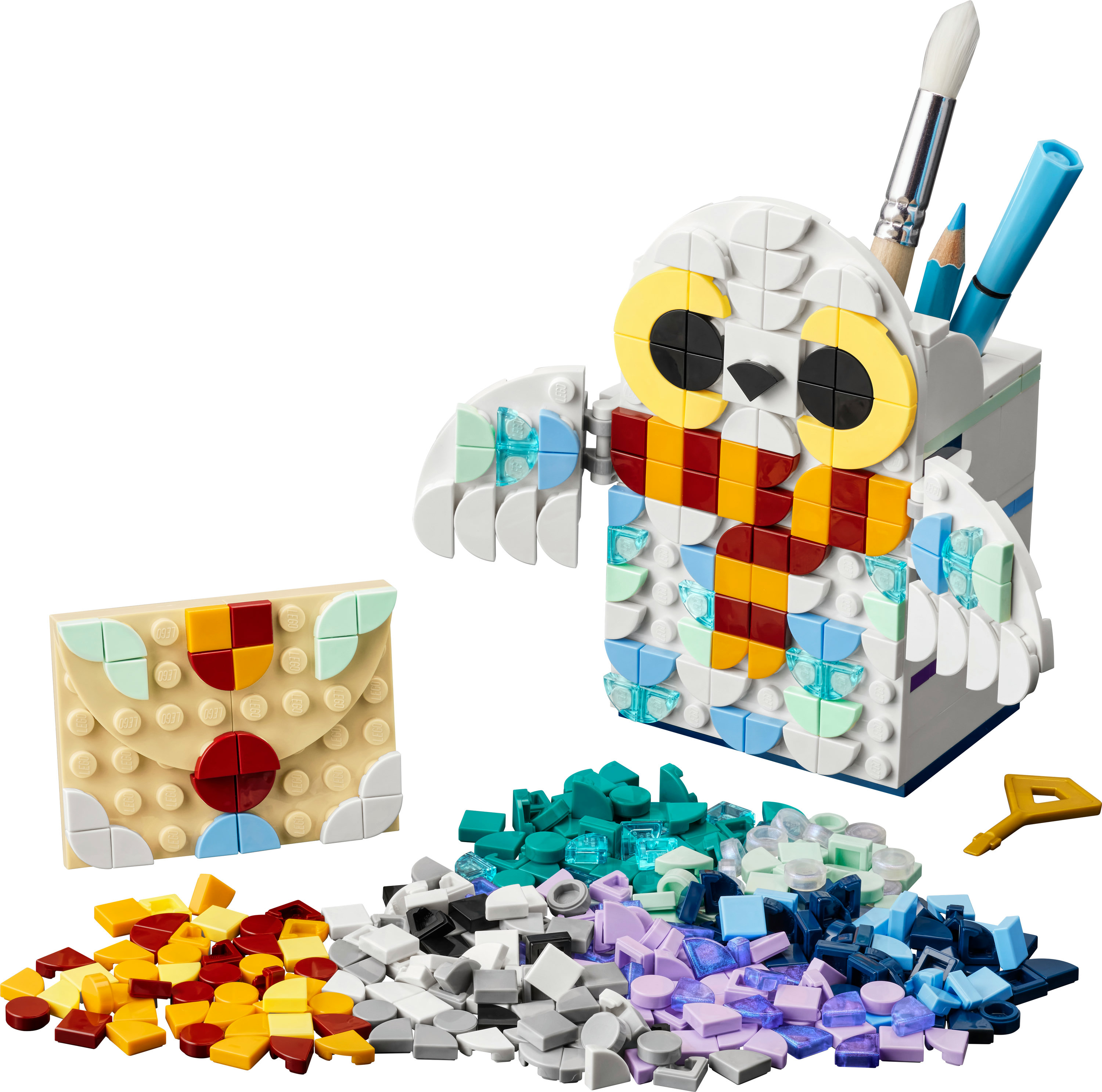 LEGO Eulen-Stifthalter mit Stiften und Bleistift, sowie einem Umschlag und losen LEGO-Steinen.