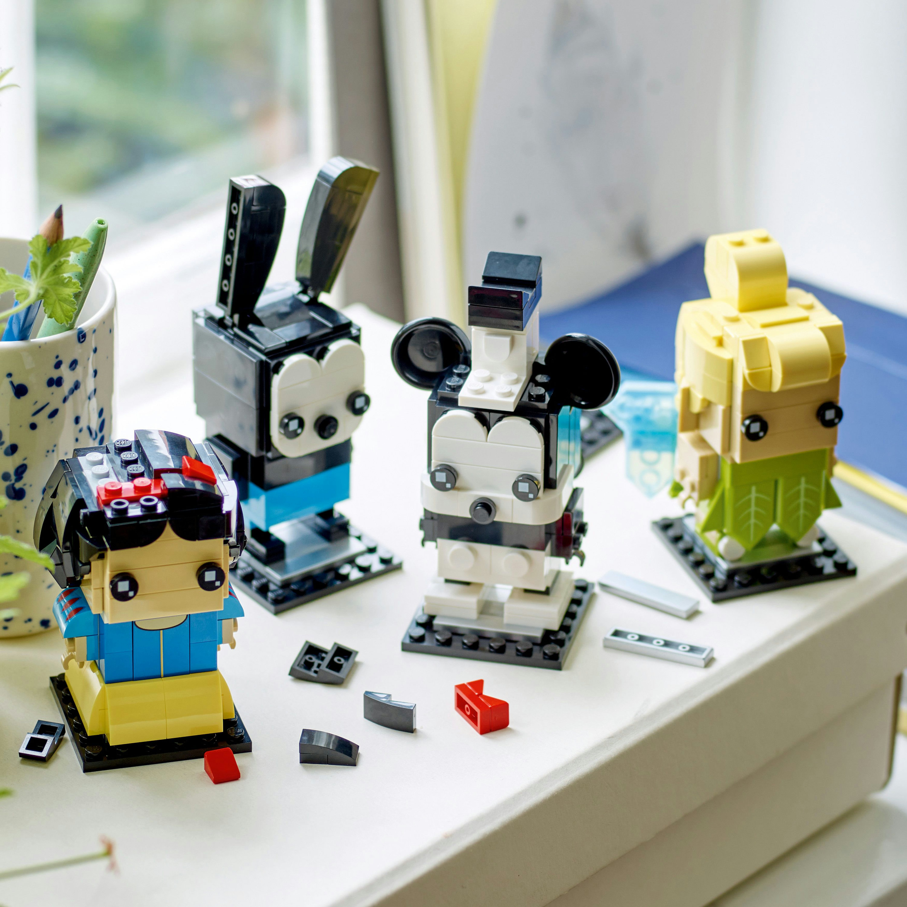 Zestaw Lego BrickHeadz z Królewną Śnieżką, Miki, Minnie i żółtą figurką wróżki.