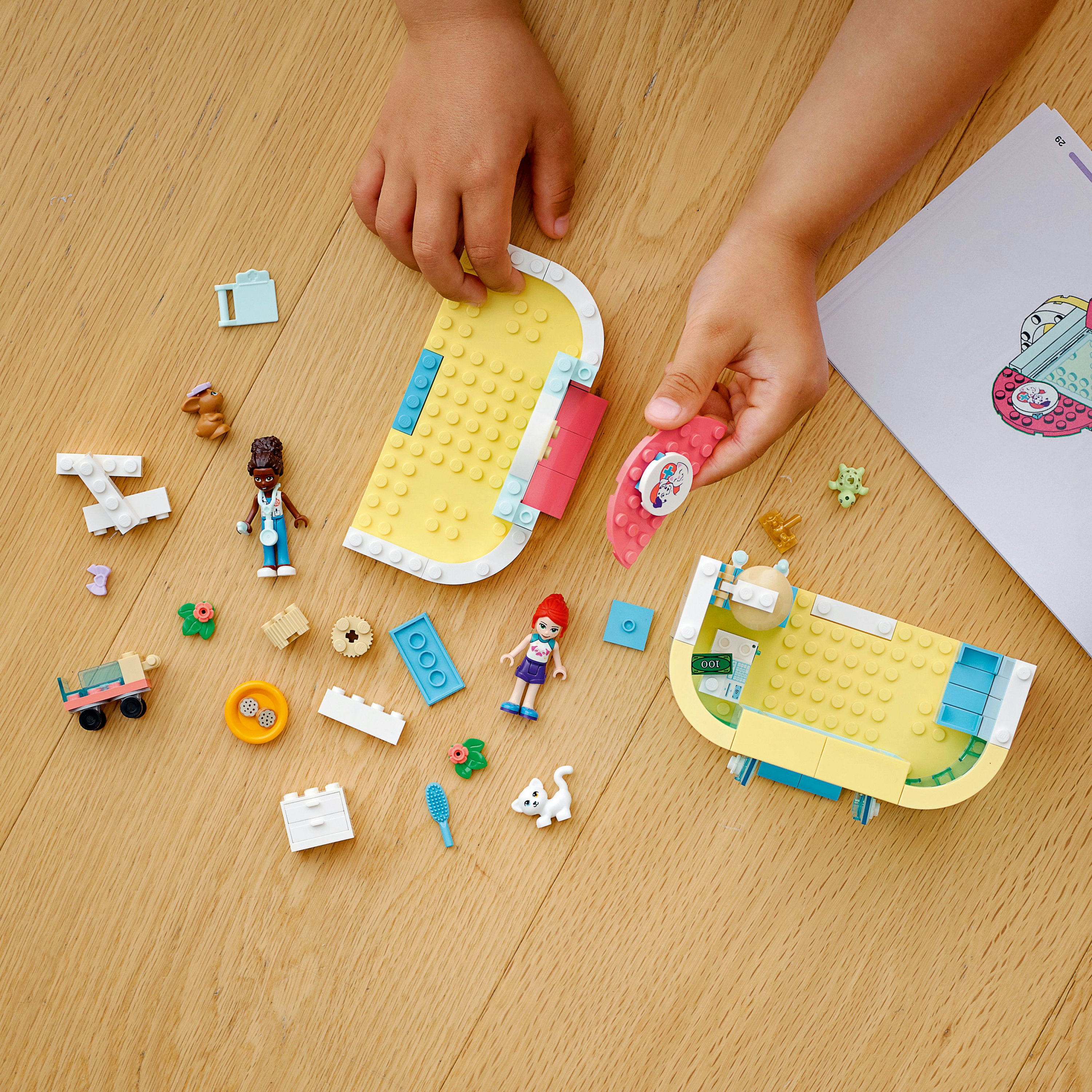 Lego set met kinderhanden die stukken rangschikken. Inclusief figuren, structuren en diverse kleurrijke elementen.