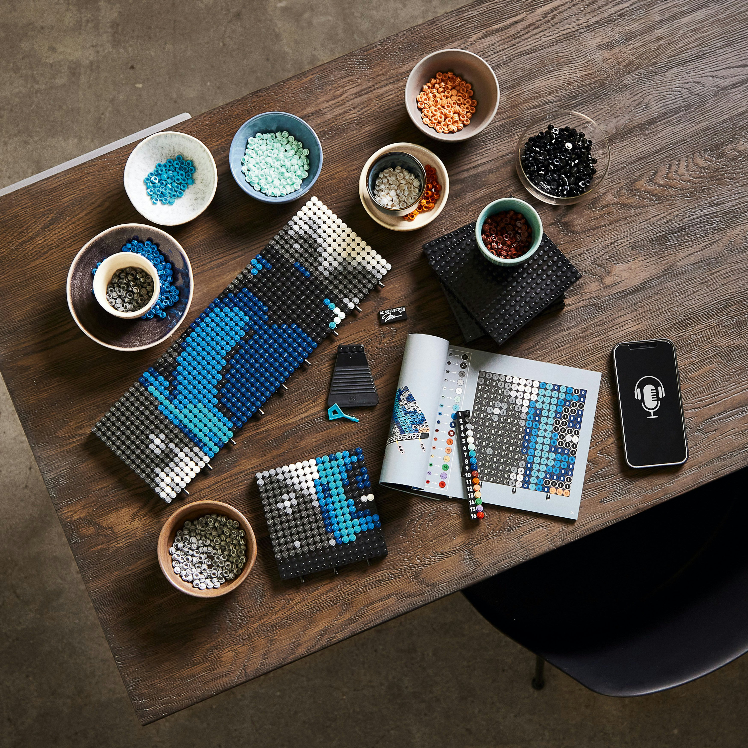 Zestaw Lego Art z koralikami i instrukcjami. Drewniany stół z różnymi kolorami.