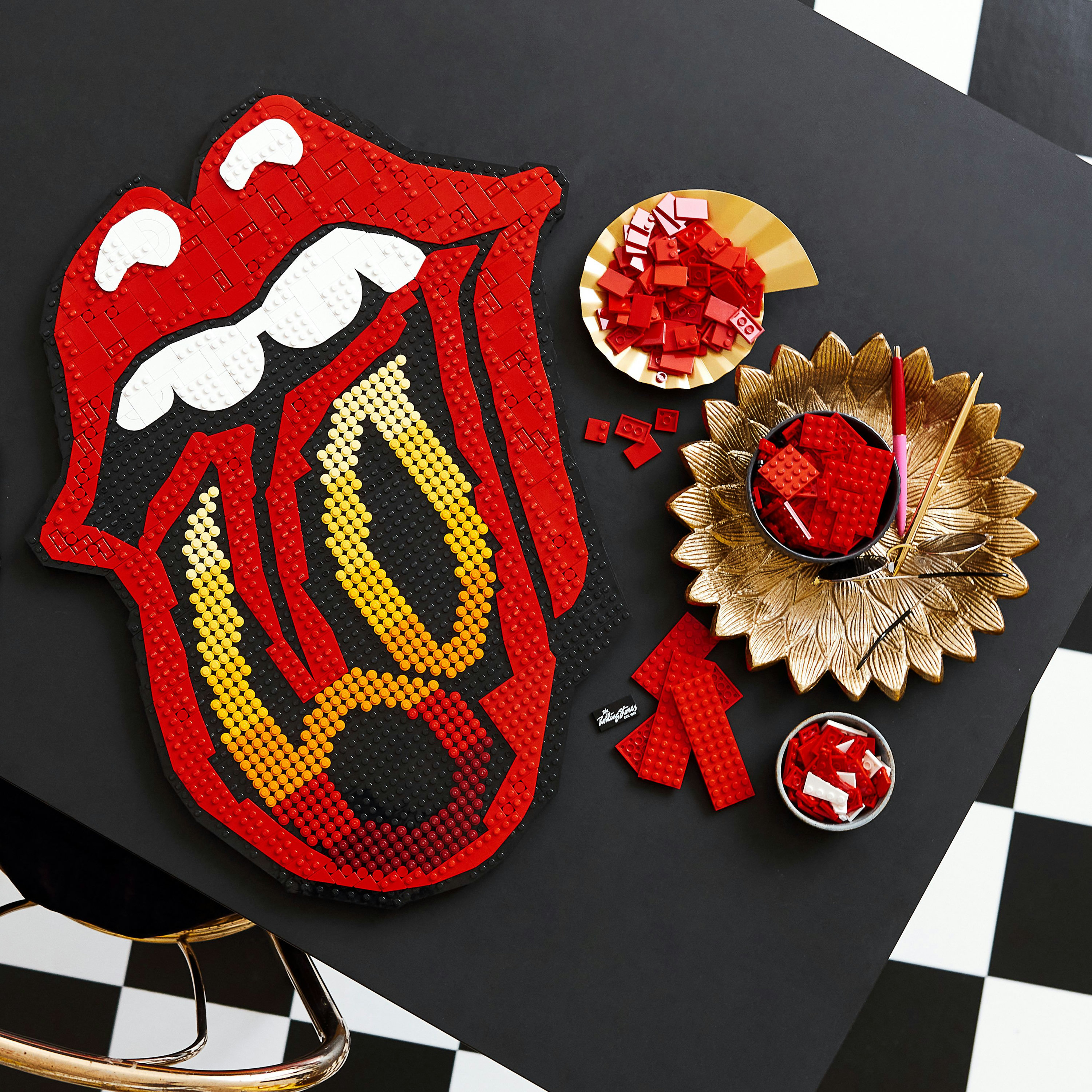 Zestaw Lego Art przedstawiający logo ust The Rolling Stones. Zawiera czerwone klocki i złotą tacę.