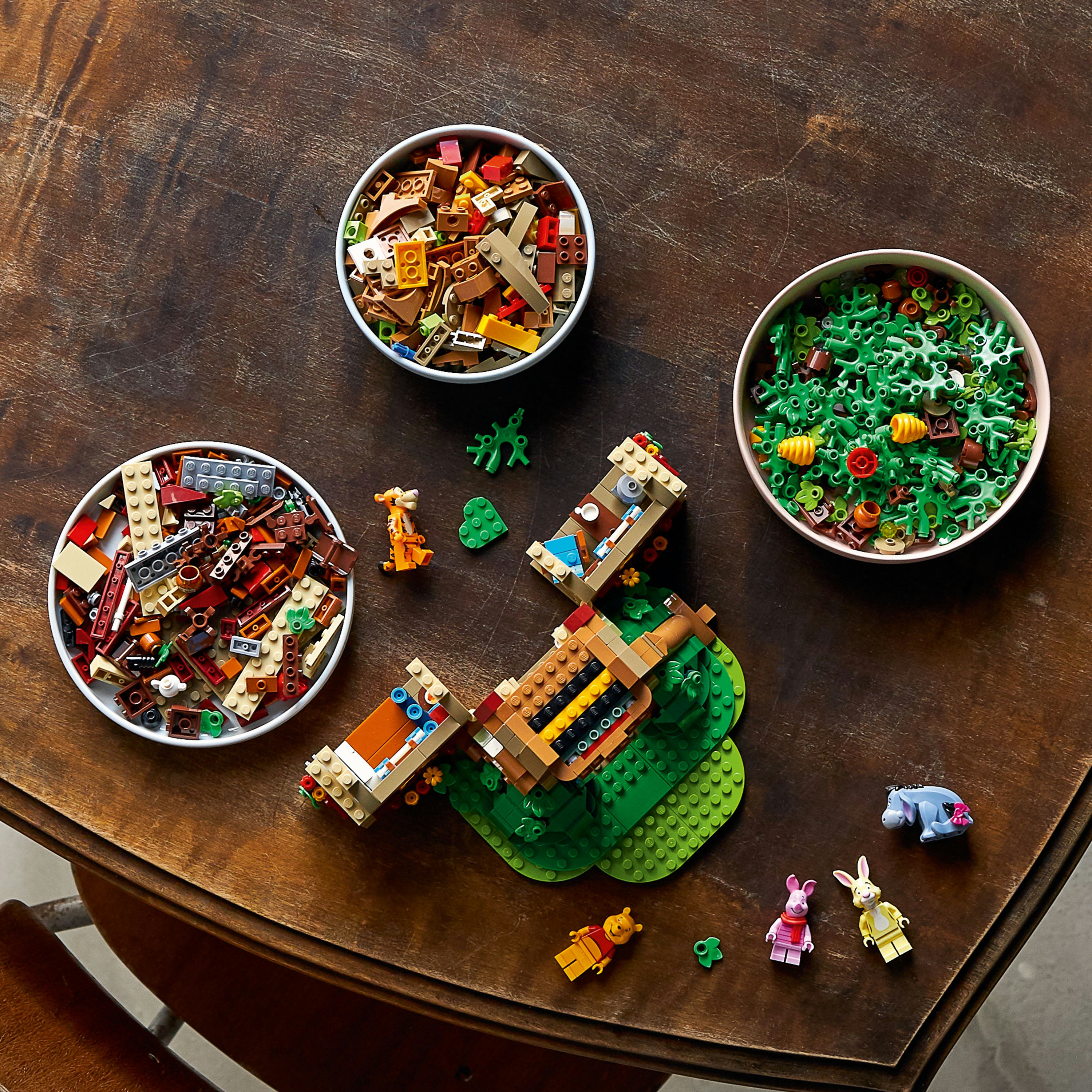 Zestaw Lego z miskami klocków Lego, Kubusiem Puchatkiem, Prosiaczkiem, Kłapouchym i małym domkiem.