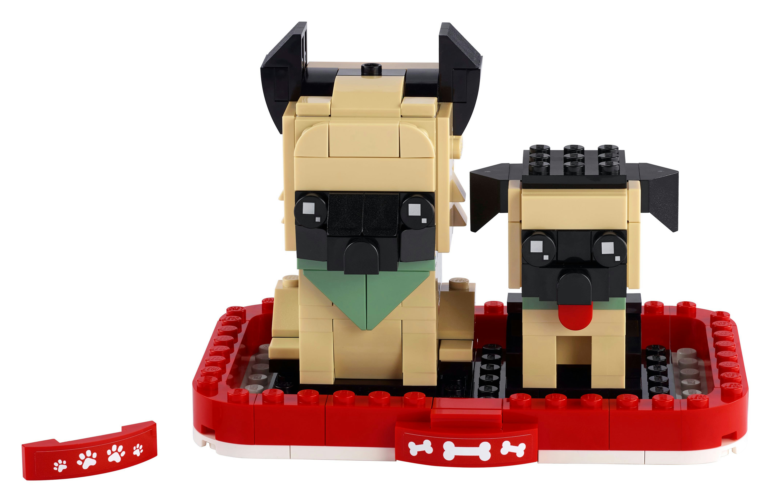 Cani carlini LEGO, uno grande e uno piccolo, in un letto rosso con dettagli di ossa e impronte.