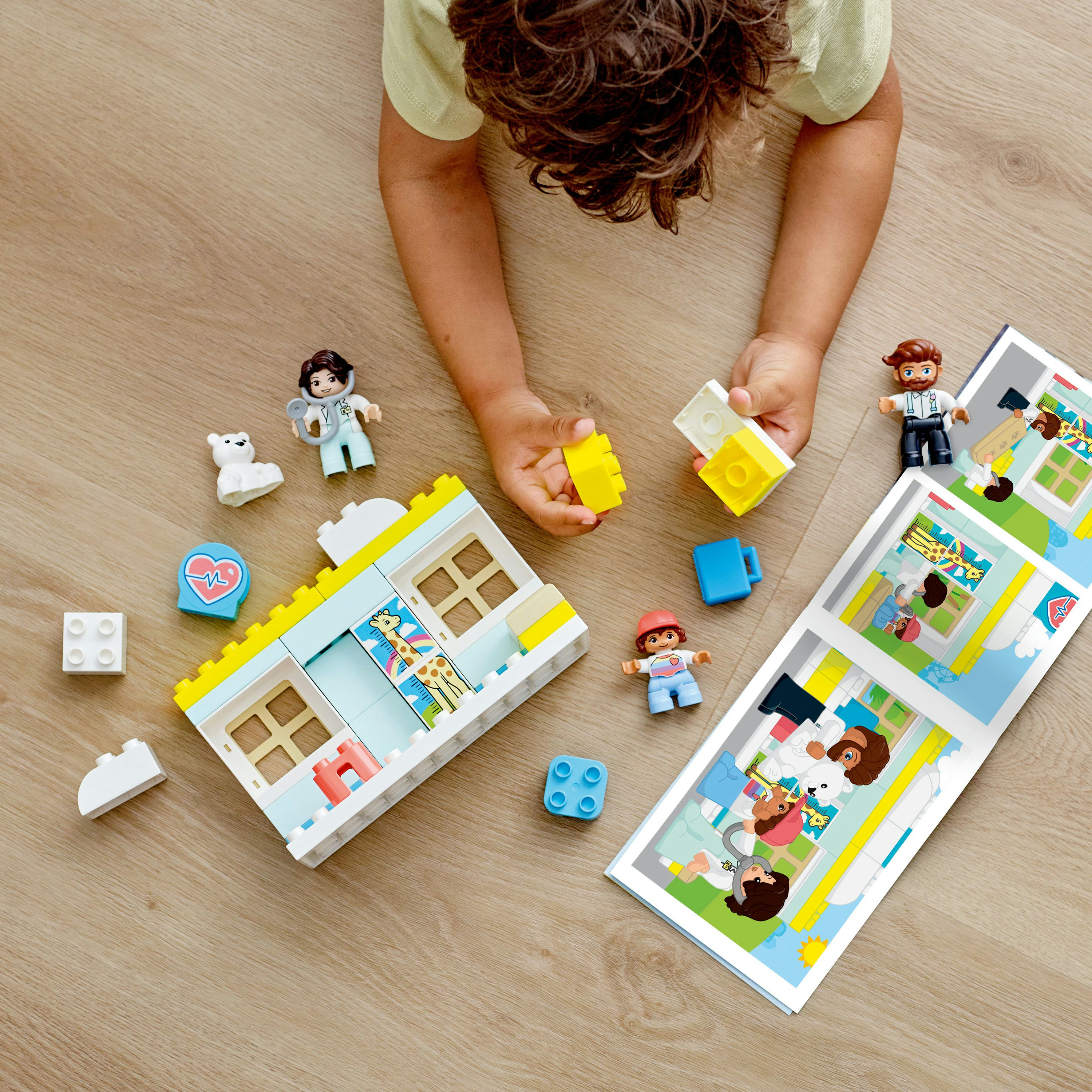 Lego Duplo Set mit Figuren, Blöcken und einer gedruckten Szene.