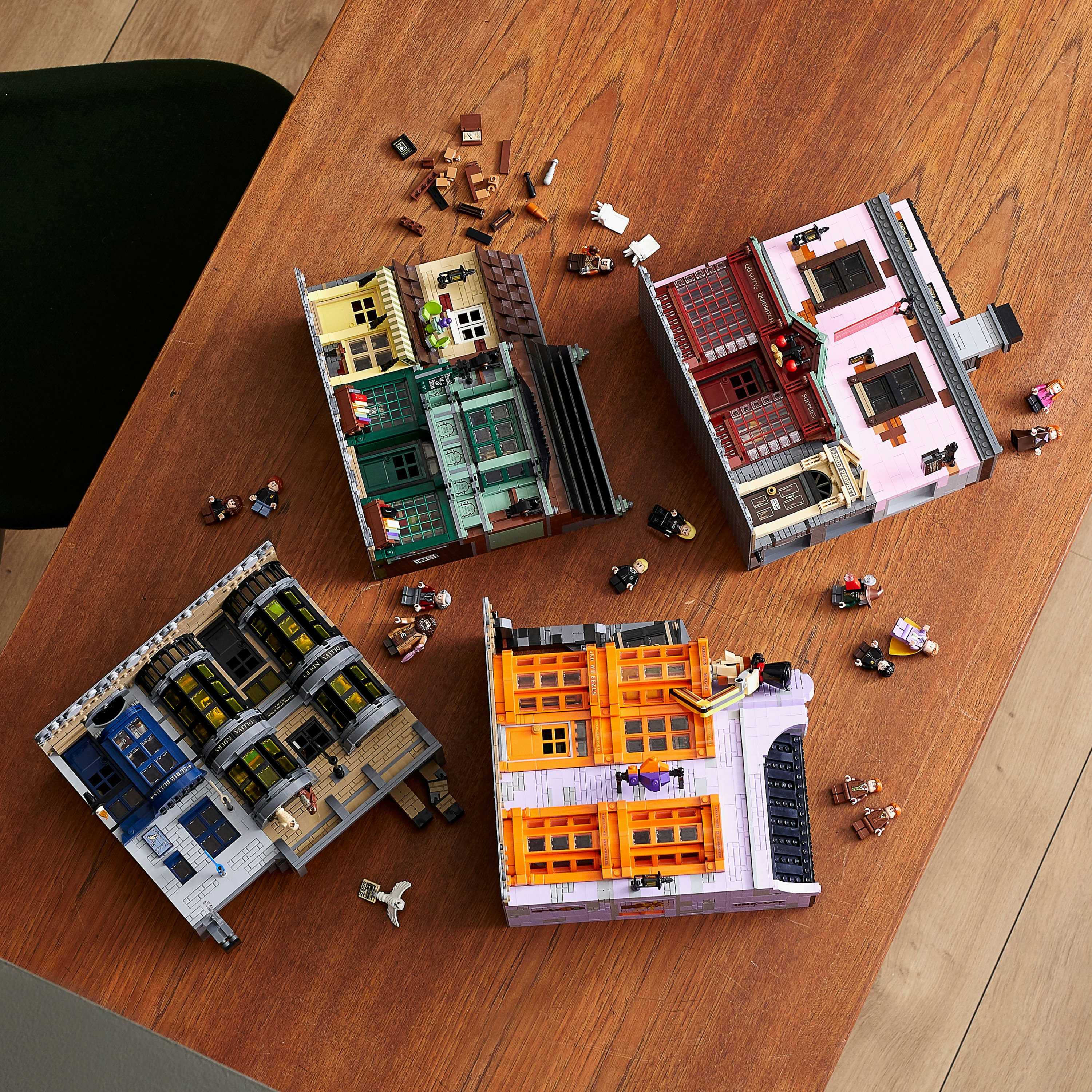 Budynki LEGO. Istnieją trzy budynki o różnych kolorach i wzorach. Zestaw jest na stole.