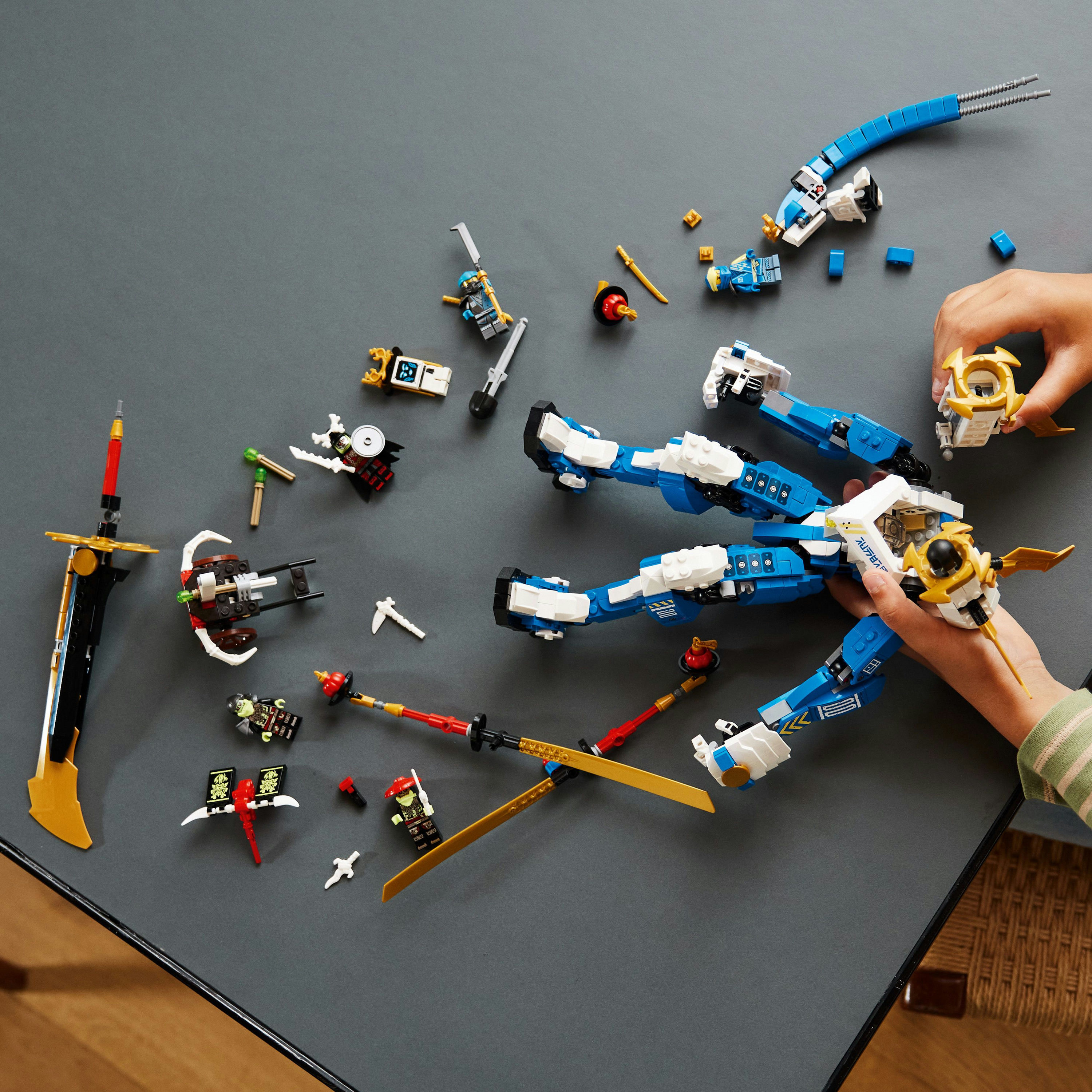Lego Ninjago Set mit Figuren und Waffen. Enthält einen großen blau-weißen Drachen und Ninja-Figuren.