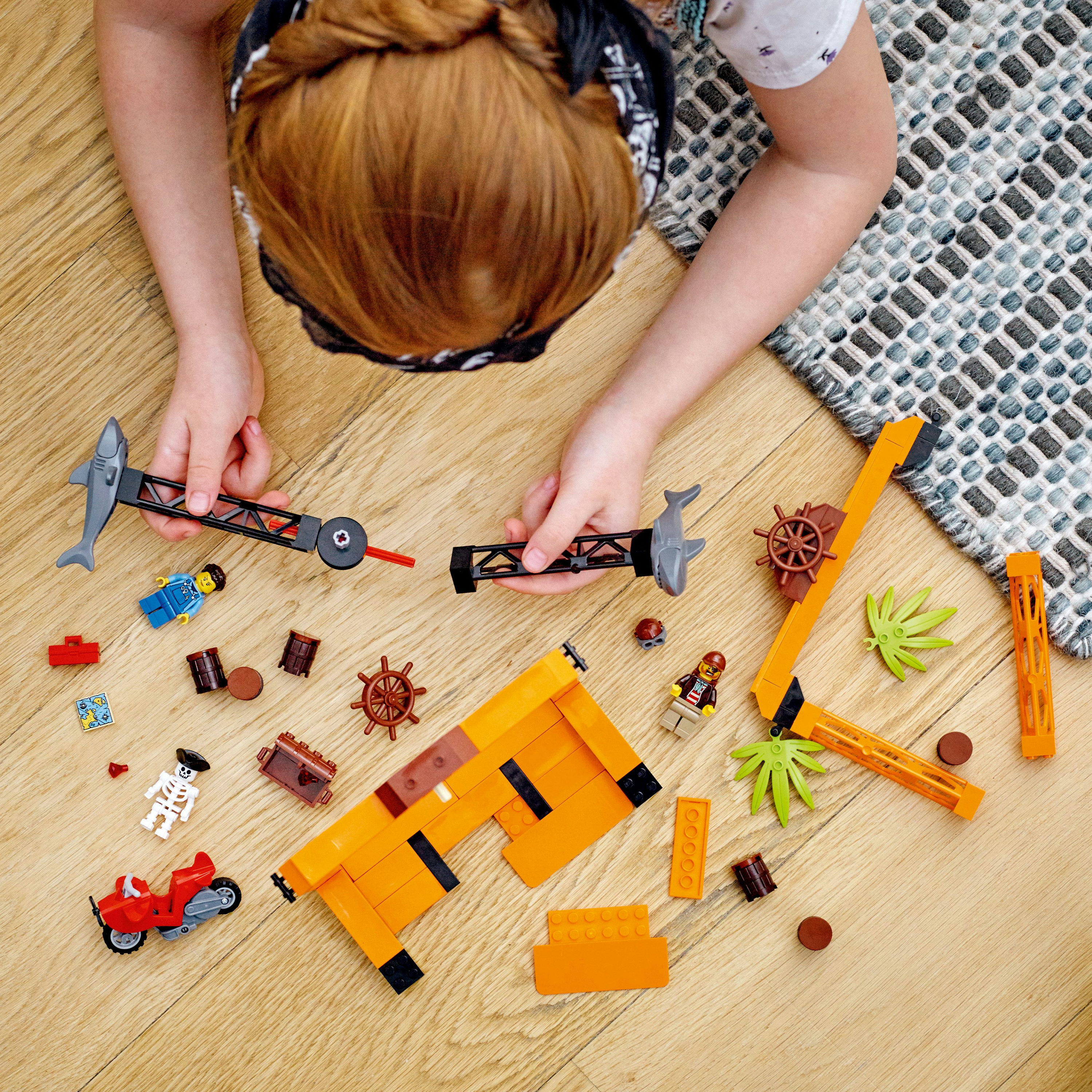 Kind dat een Lego piraten-thema set in elkaar zet, met piratenfiguren en andere componenten.