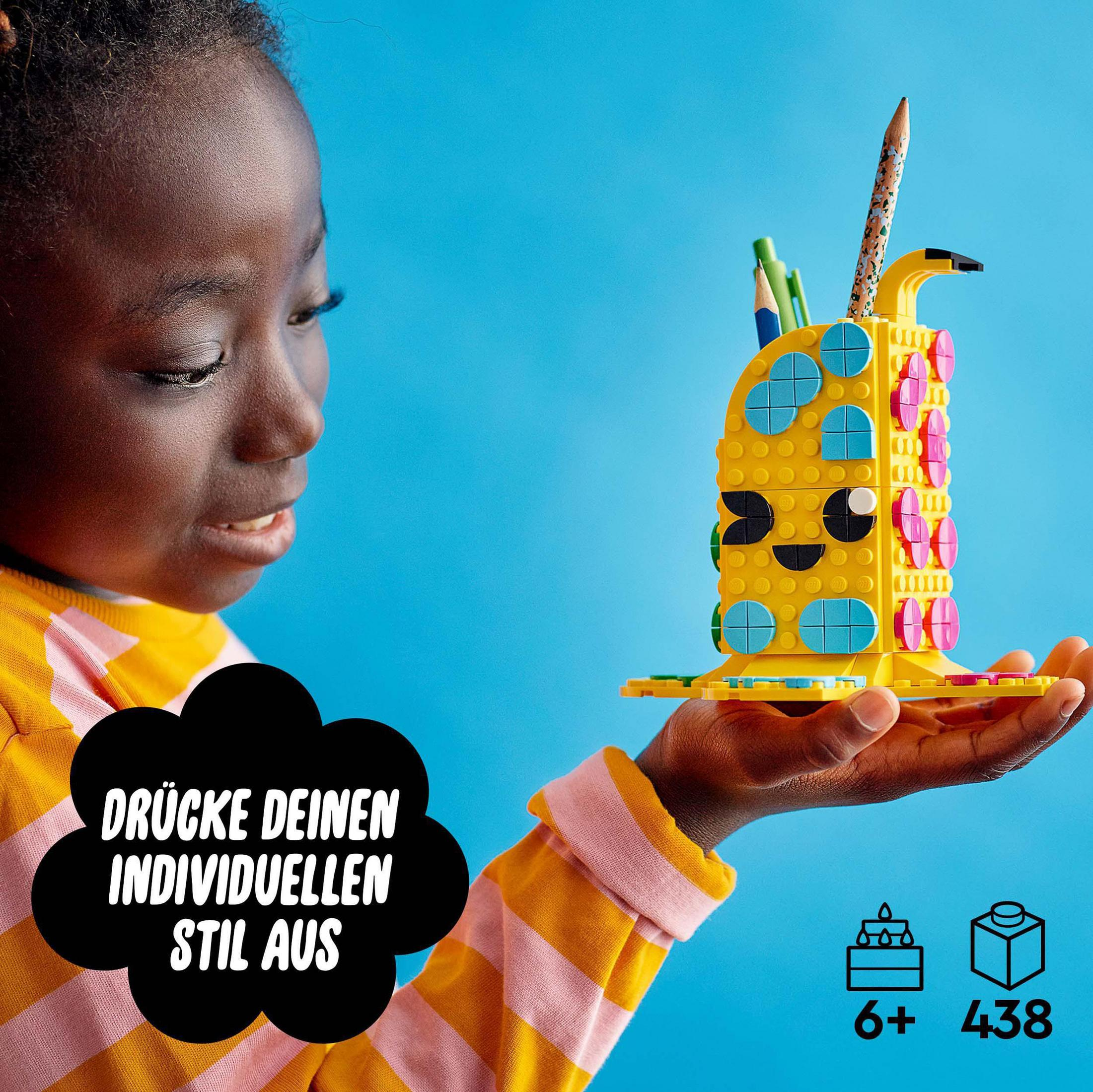 Ein Mädchen hält eine Lego-Kreation. Es ist ein gelber Stifthalter mit bunten Verzierungen.