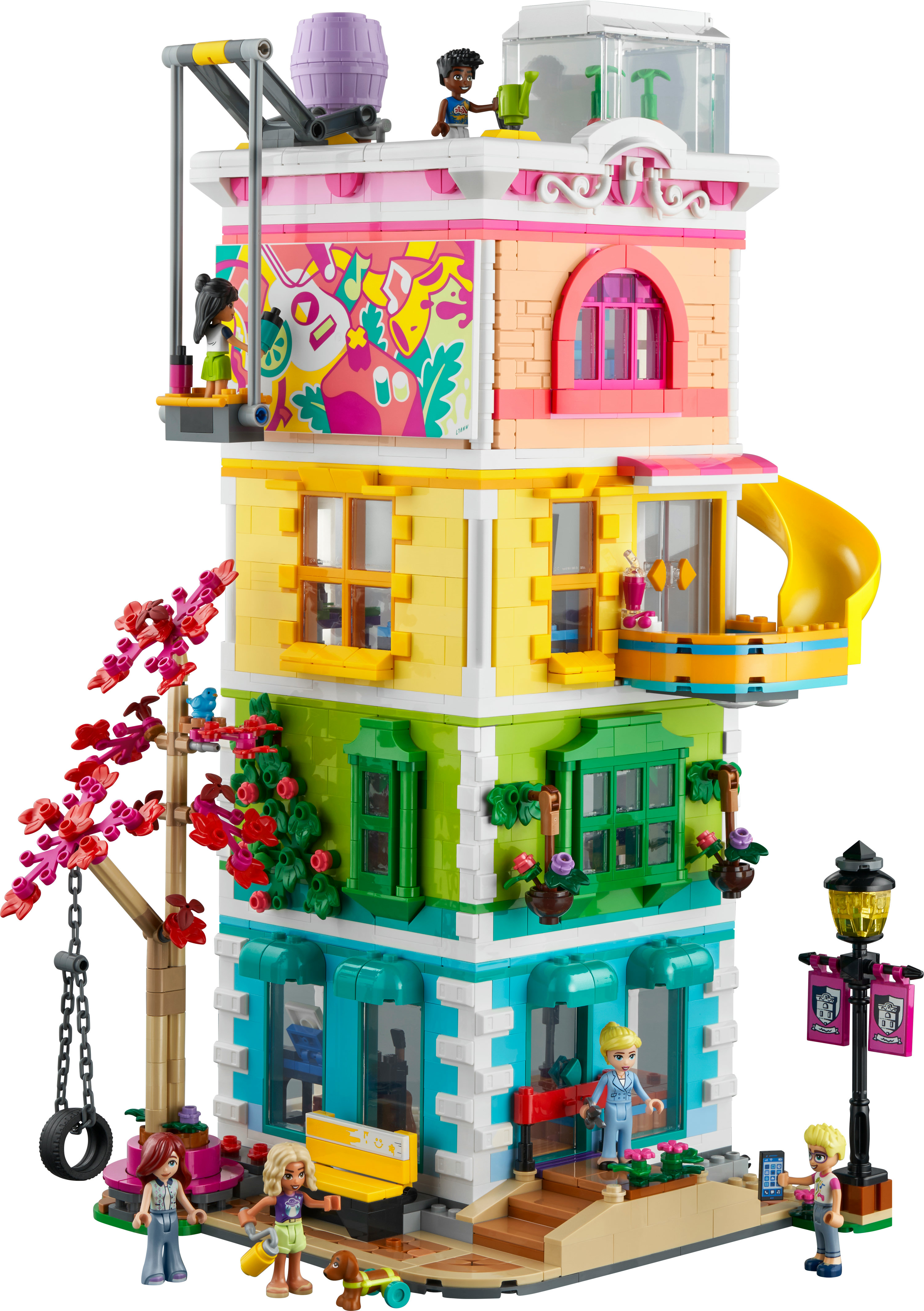 Zestaw LEGO Friends, wielopiętrowy budynek z figurkami i zjeżdżalnią. Jasny, kolorowy design.