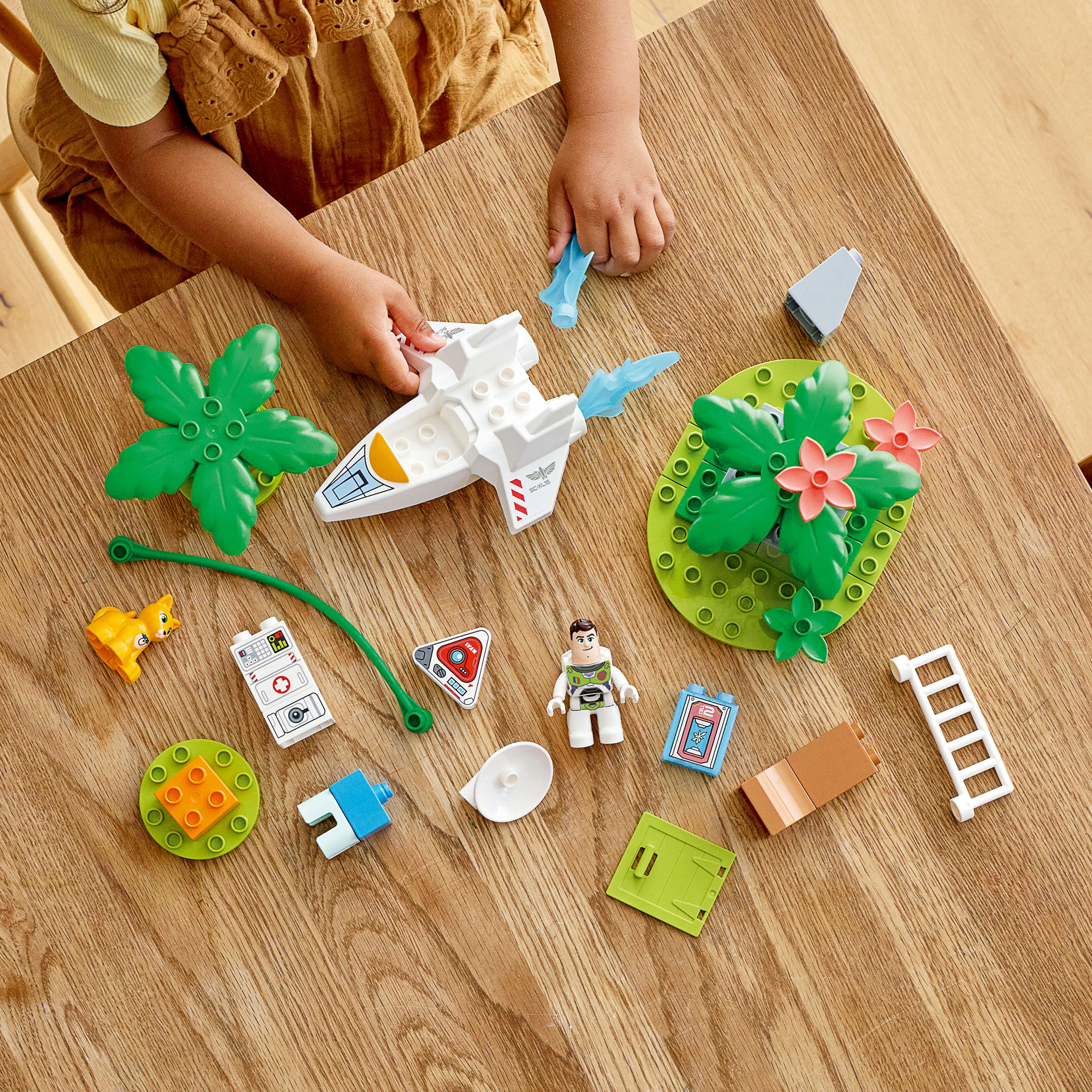 Ein Kind spielt mit einem Lego-Set. Es gibt ein Raumschiff, eine Figur und verschiedene Lego-Teile.