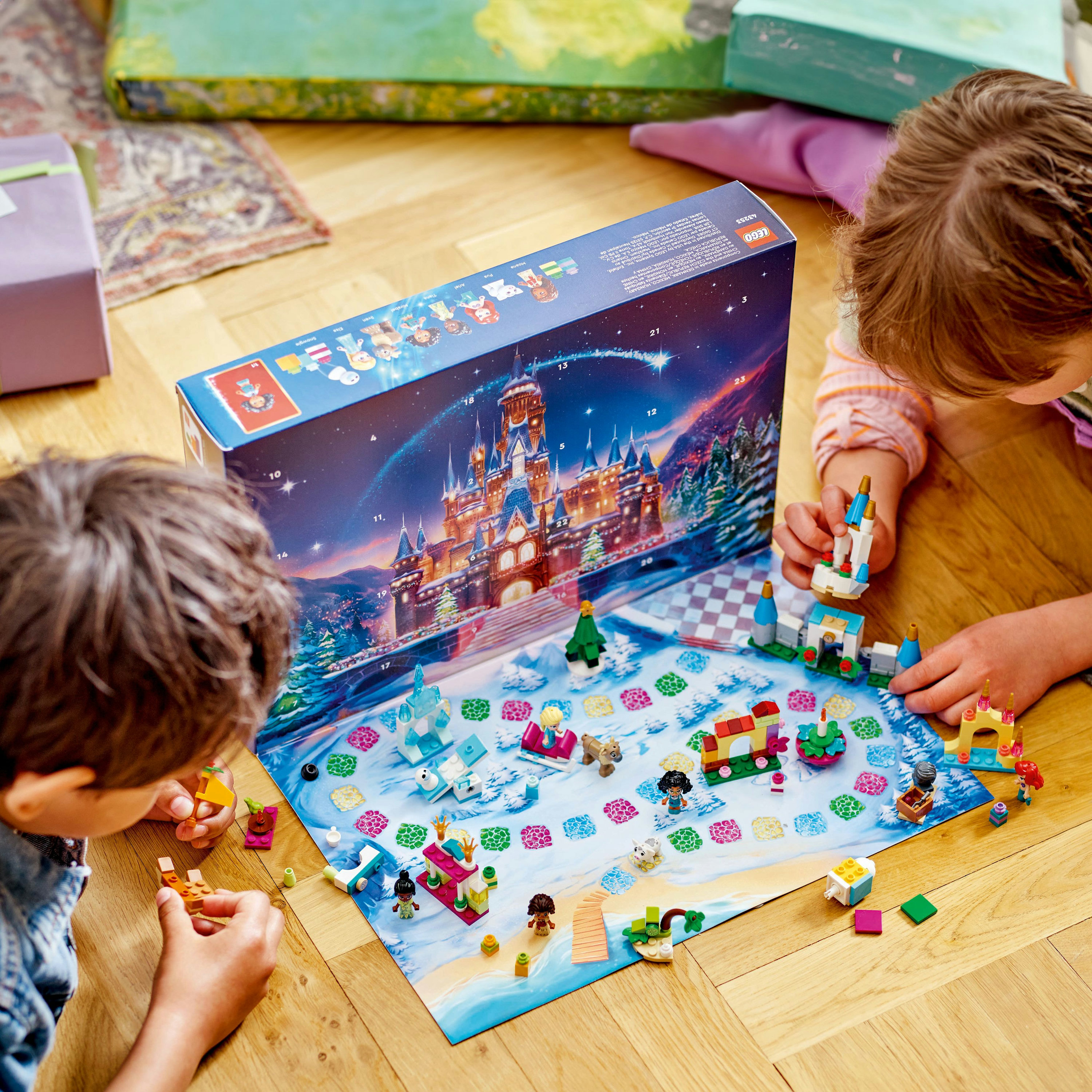 Dos niños construyendo una escena del Calendario de Adviento de Lego, con un castillo y figuras.