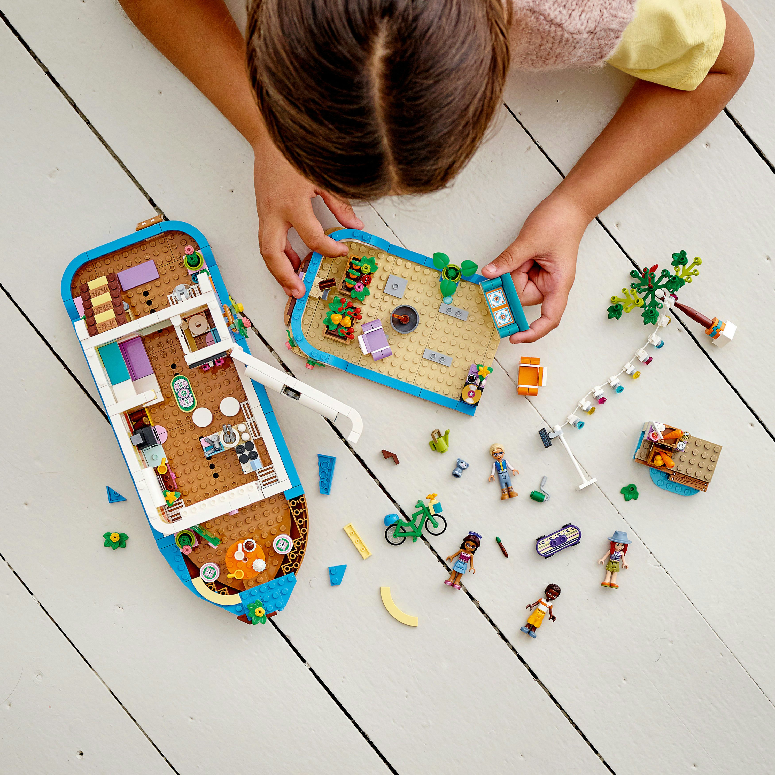 Die Sicht eines Kindes auf ein Lego Friends-Set, mit Figuren und einer Bootsstruktur.
