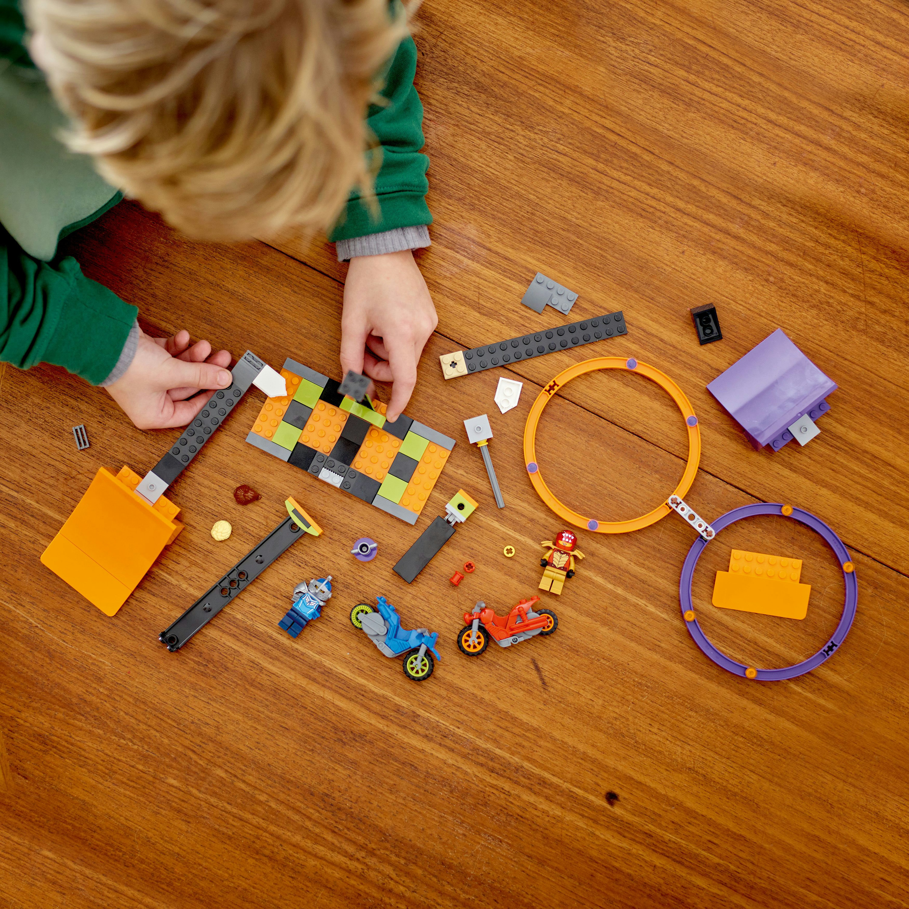 Manos de niño ensamblando ladrillos Lego, con varias piezas de Lego.
