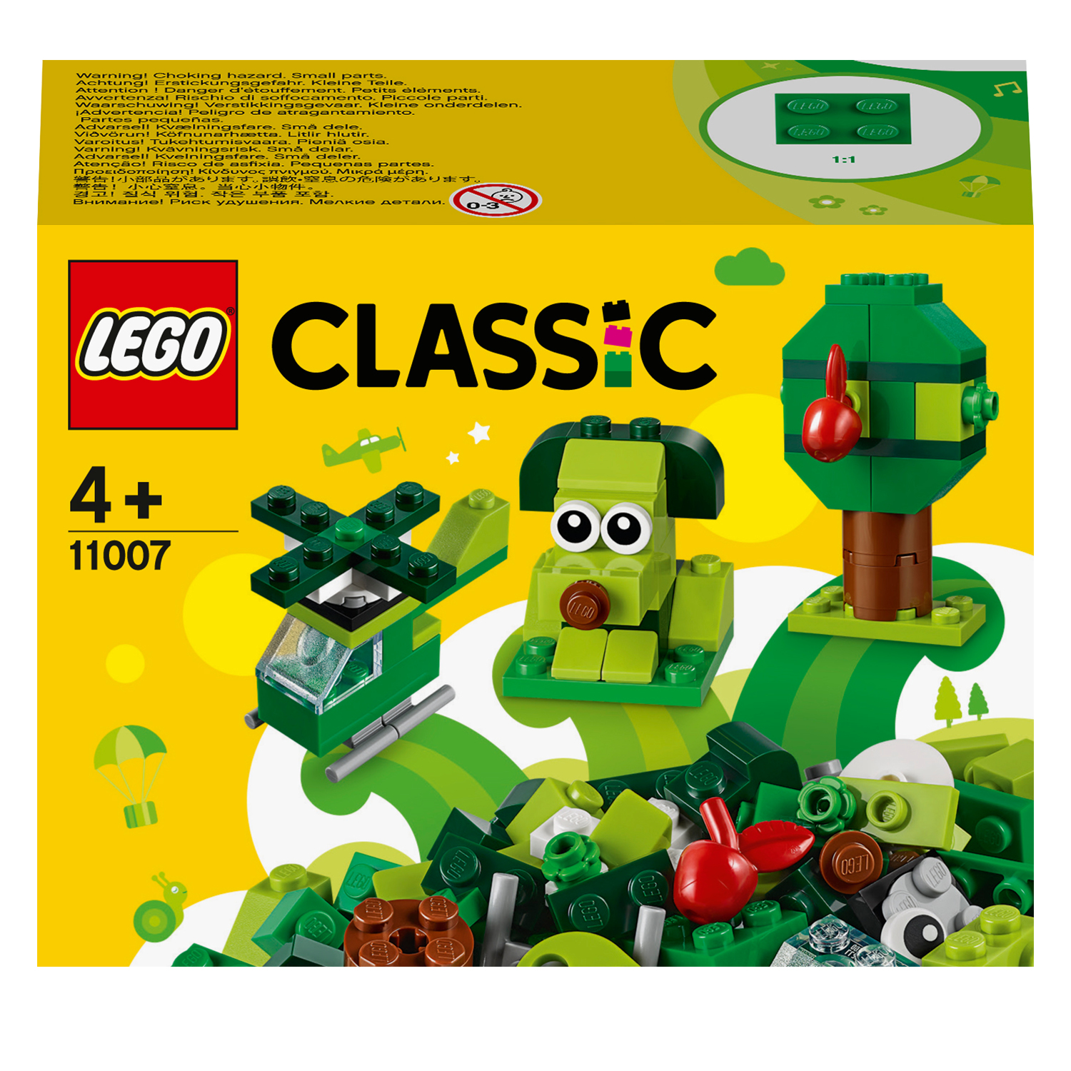 Una scatola del set Lego Classic con mattoncini verdi, un albero, un elicottero e una figura di cane.
