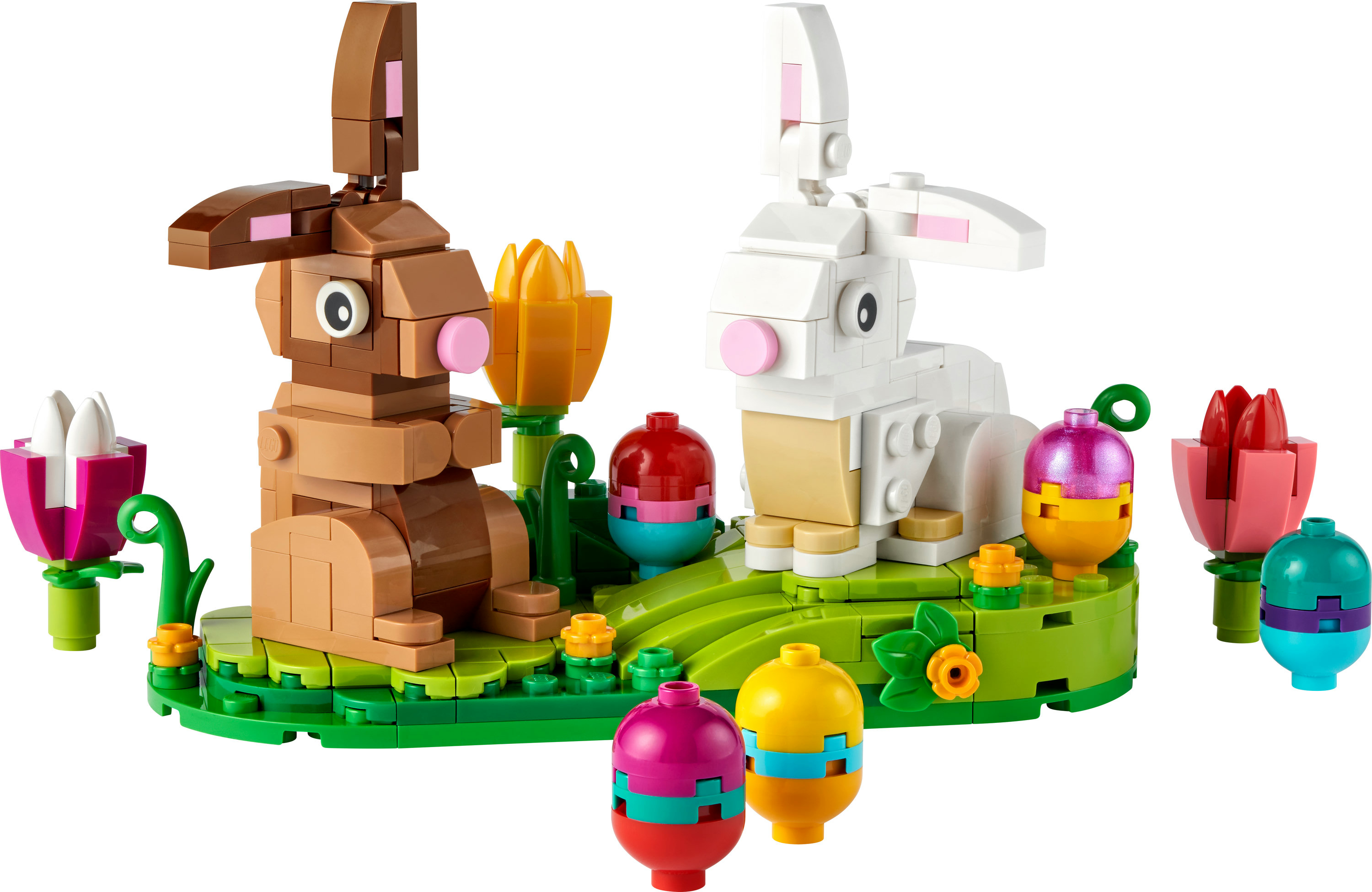 Yeşil bir taban üzerinde iki Paskalya tavşanı, çiçekler ve dekore edilmiş Paskalya yumurtaları içeren bir Lego seti.