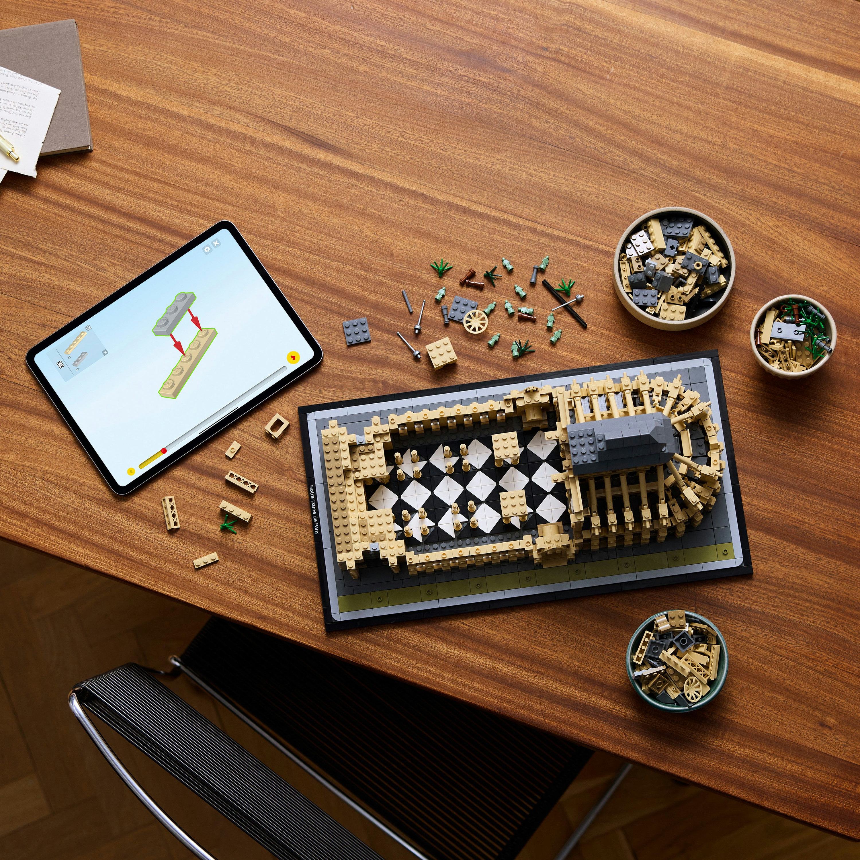 Model Lego kościoła z tabletem pokazującym instrukcje, klocki Lego na stole.