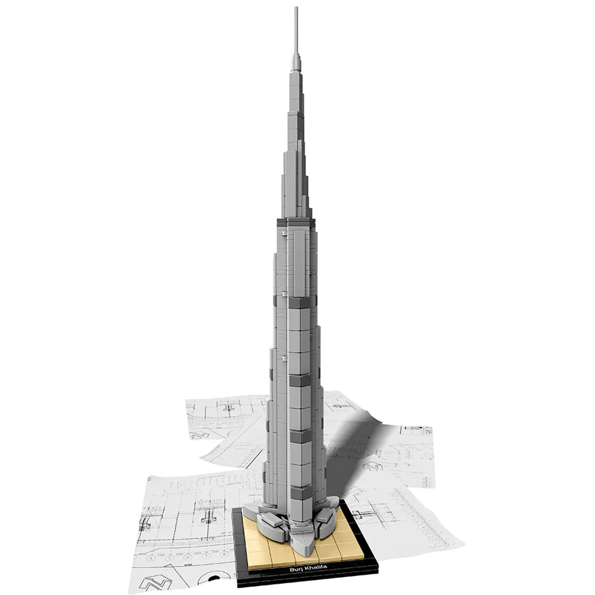 A Lego model of the Burj Khalifa on blueprints. The model is gray and on a black base.