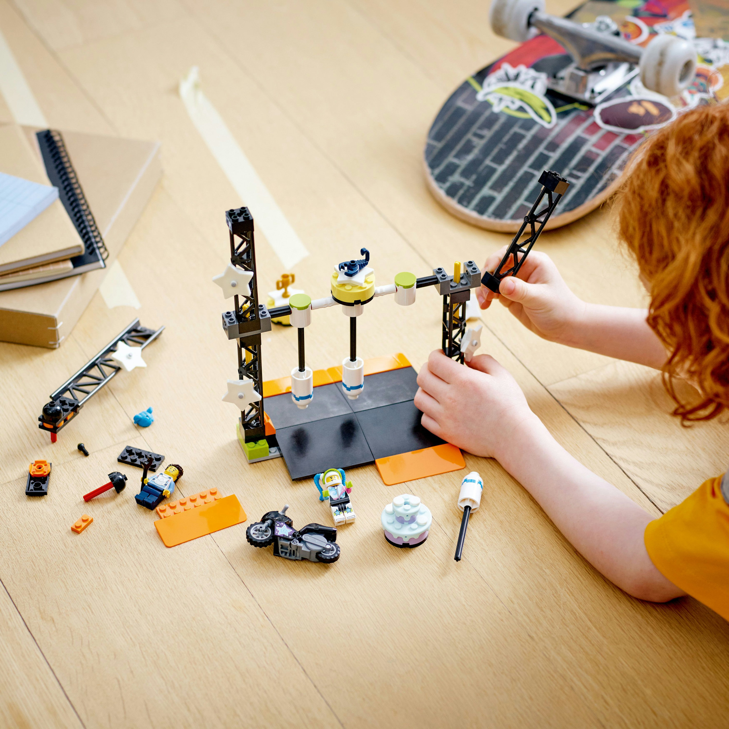 Een kind speelt met Lego. Een skateboard staat op de achtergrond.