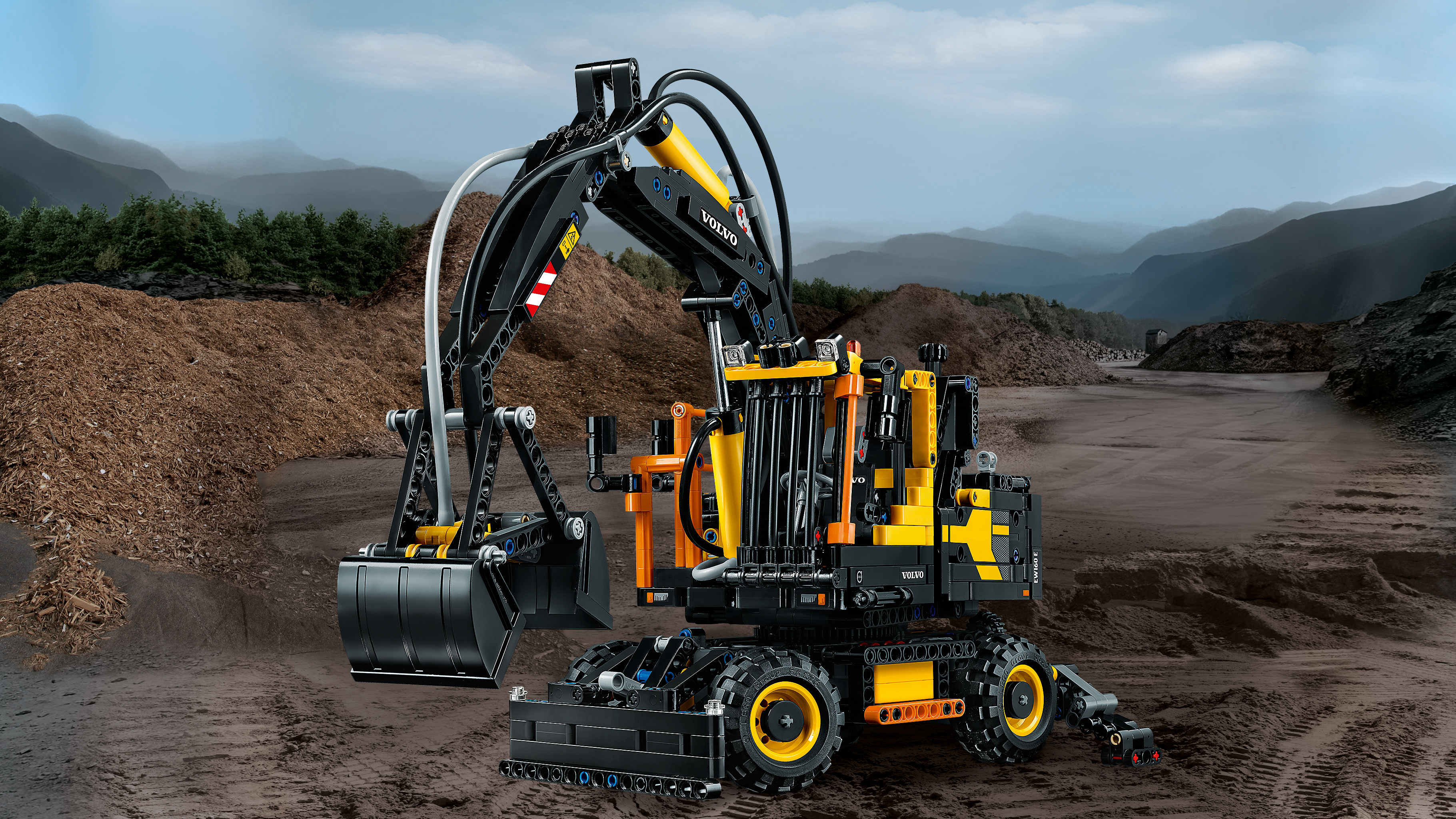 Lego Technic Volvo graafmachine model op een achtergrond van aarde en lucht.