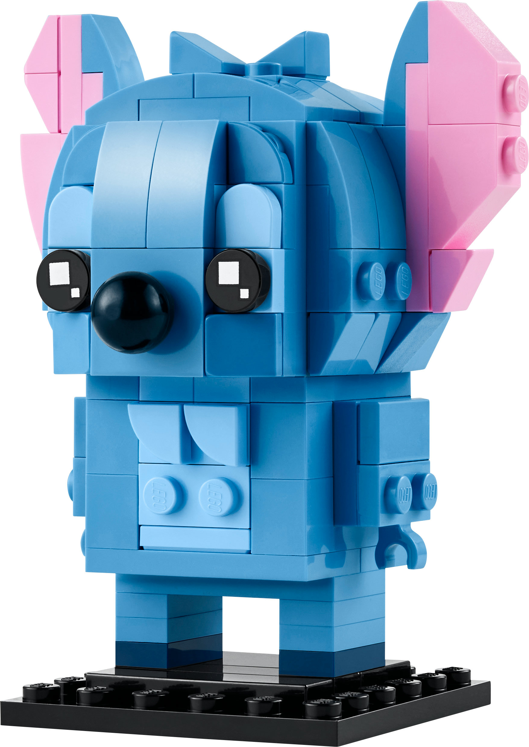 LEGO Stitch figürü, pembe kulaklı mavi, siyah bir taban üzerinde duruyor. Beyaz zemin.
