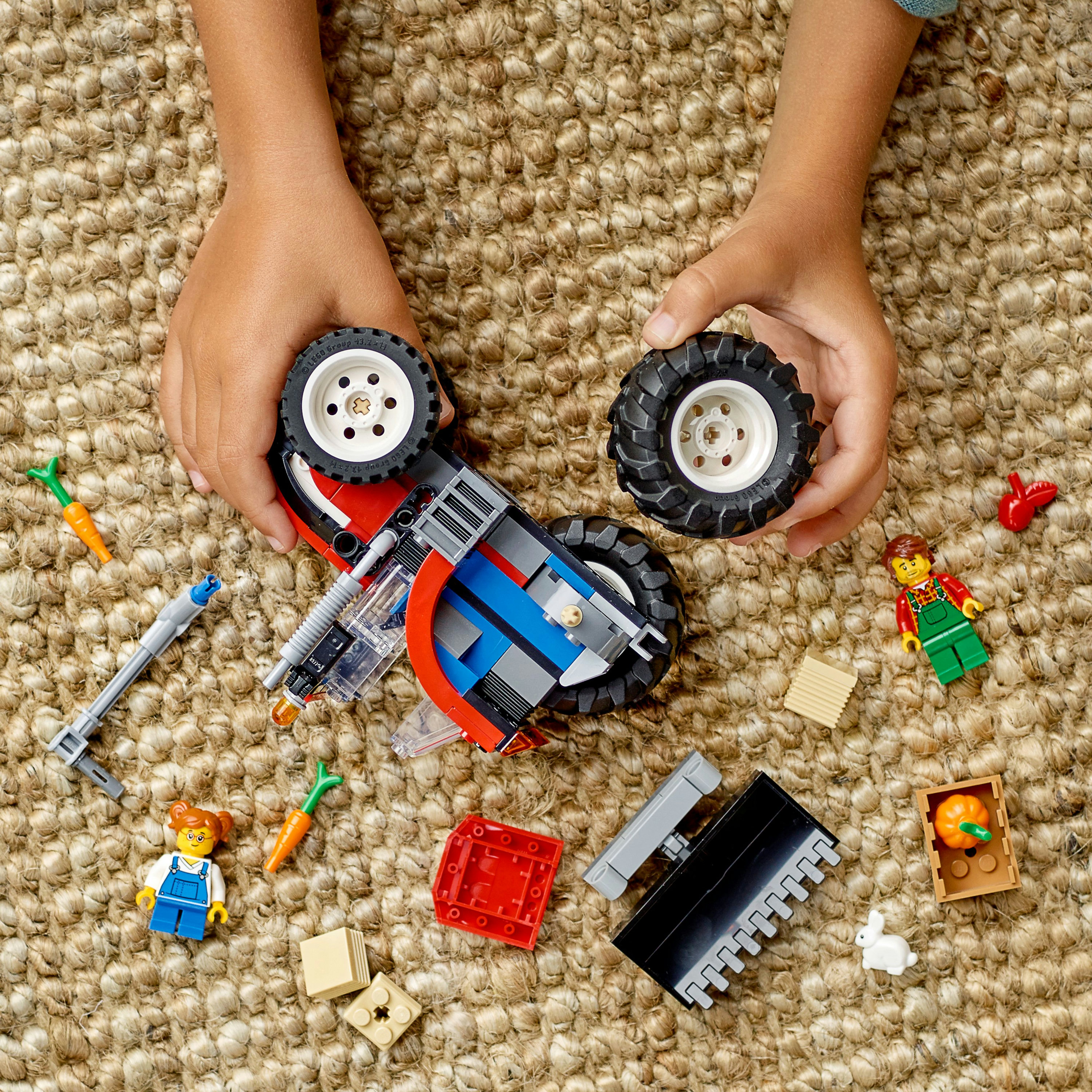 Kinderhände interagieren mit einem Lego-Set. Komponenten wie Karotten und ein Spielzeughase liegen auf der Oberfläche.