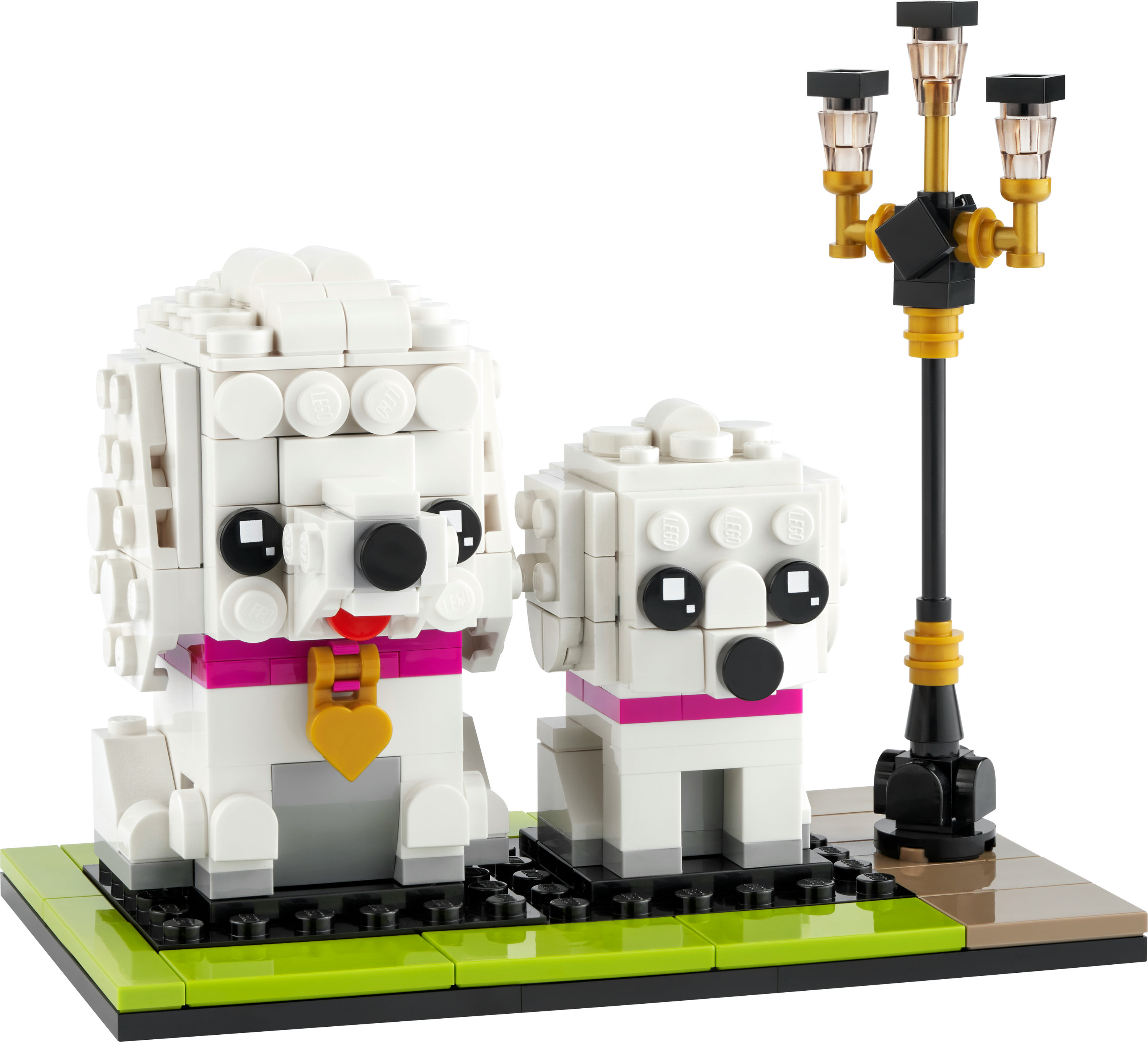 Zwei LEGO-Hunde mit rosa Halsbändern und eine Straßenlaterne. Die Hunde sind weiß. Die Szene befindet sich auf einer schwarzen und grünen Basis.