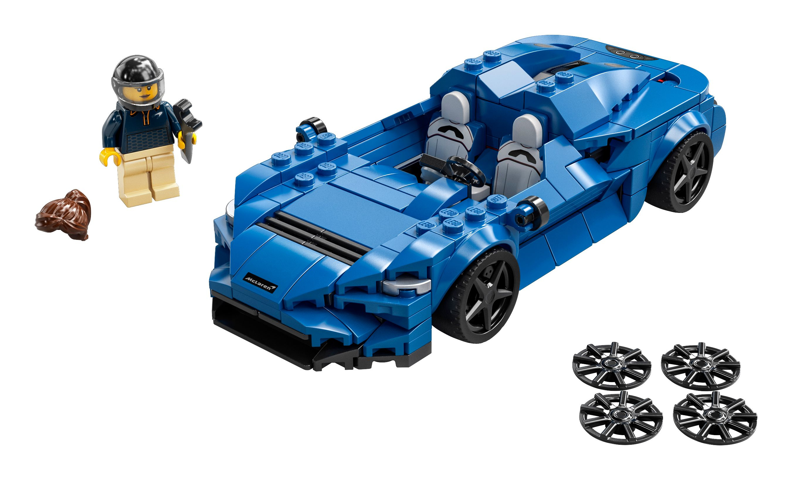 Mavi Lego araba modeli, bir minifigür ve yedek tekerlekler. Beyaz arka plan.