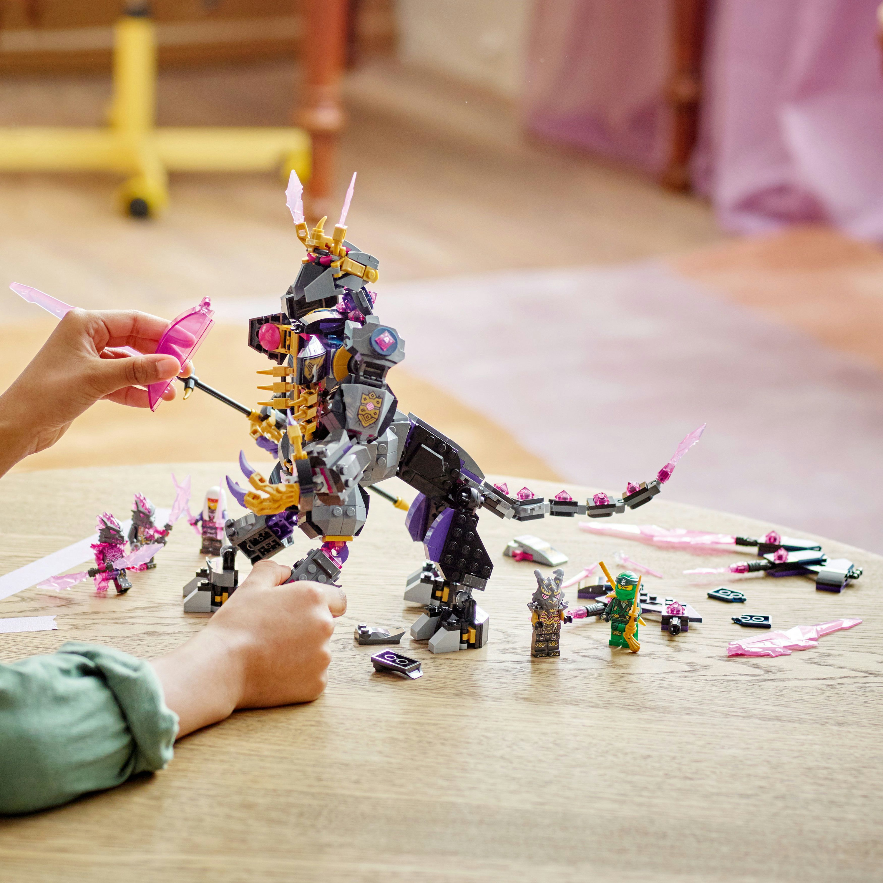 Una persona gioca con un set Lego Ninjago, con un drago e vari personaggi Lego.