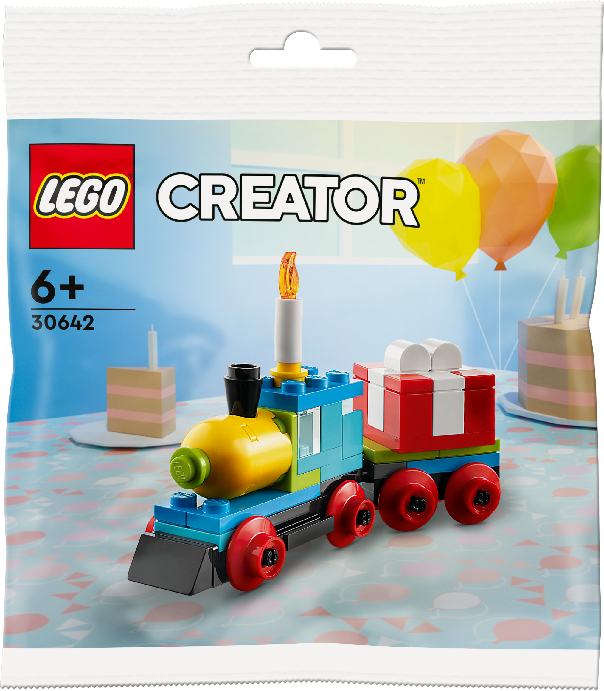 Set treno Lego Creator in una busta con palloncini, torta e un tavolo sullo sfondo.