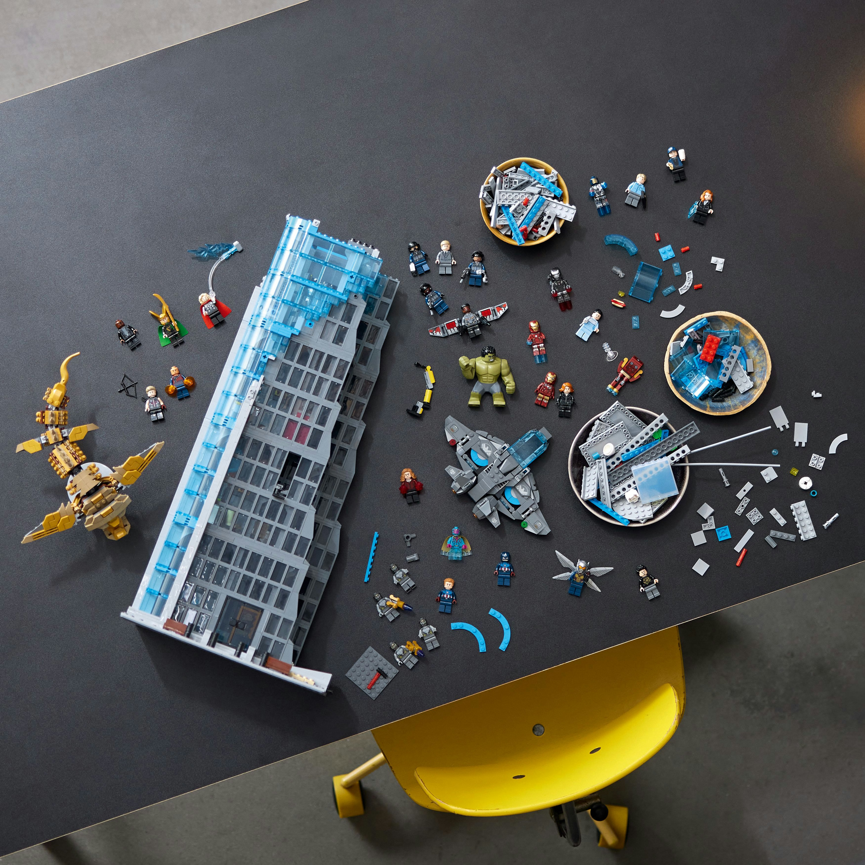 Zestaw Lego przedstawiający wieżowiec z minifigurkami i różnymi elementami konstrukcyjnymi.
