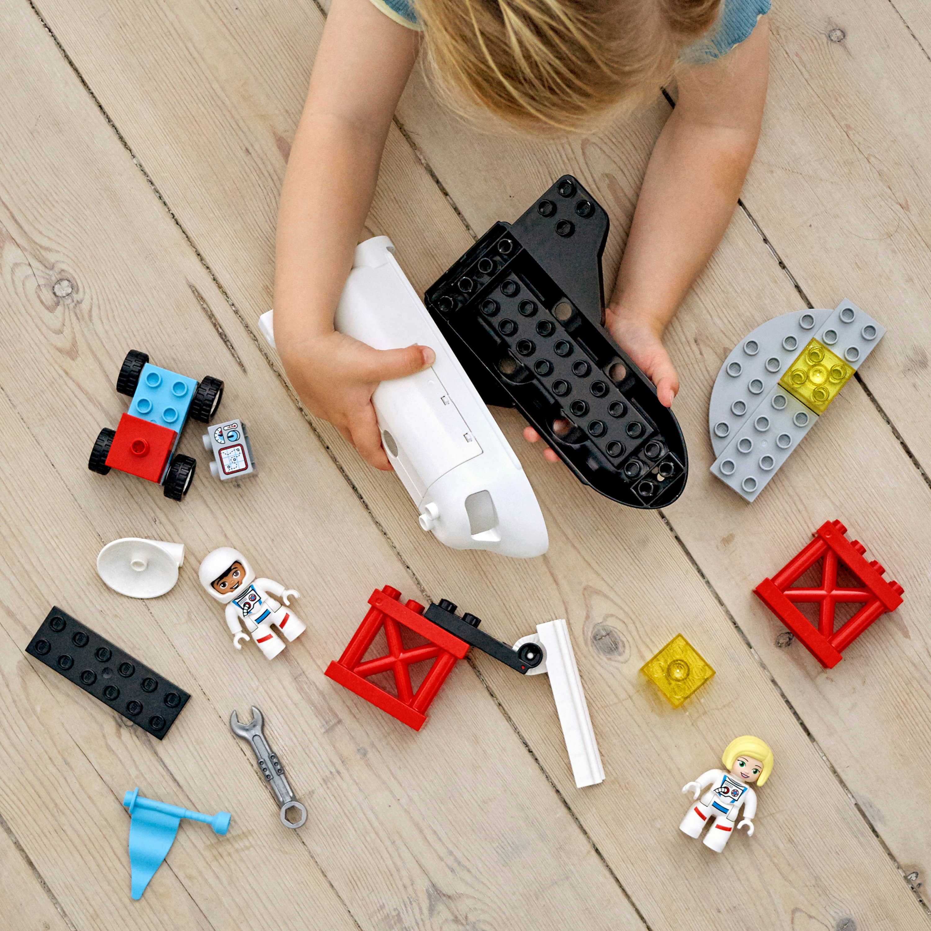 Ein Kind spielt mit Lego Duplo Weltraum-Blöcken. Enthält ein Raumschiff und Astronauten.