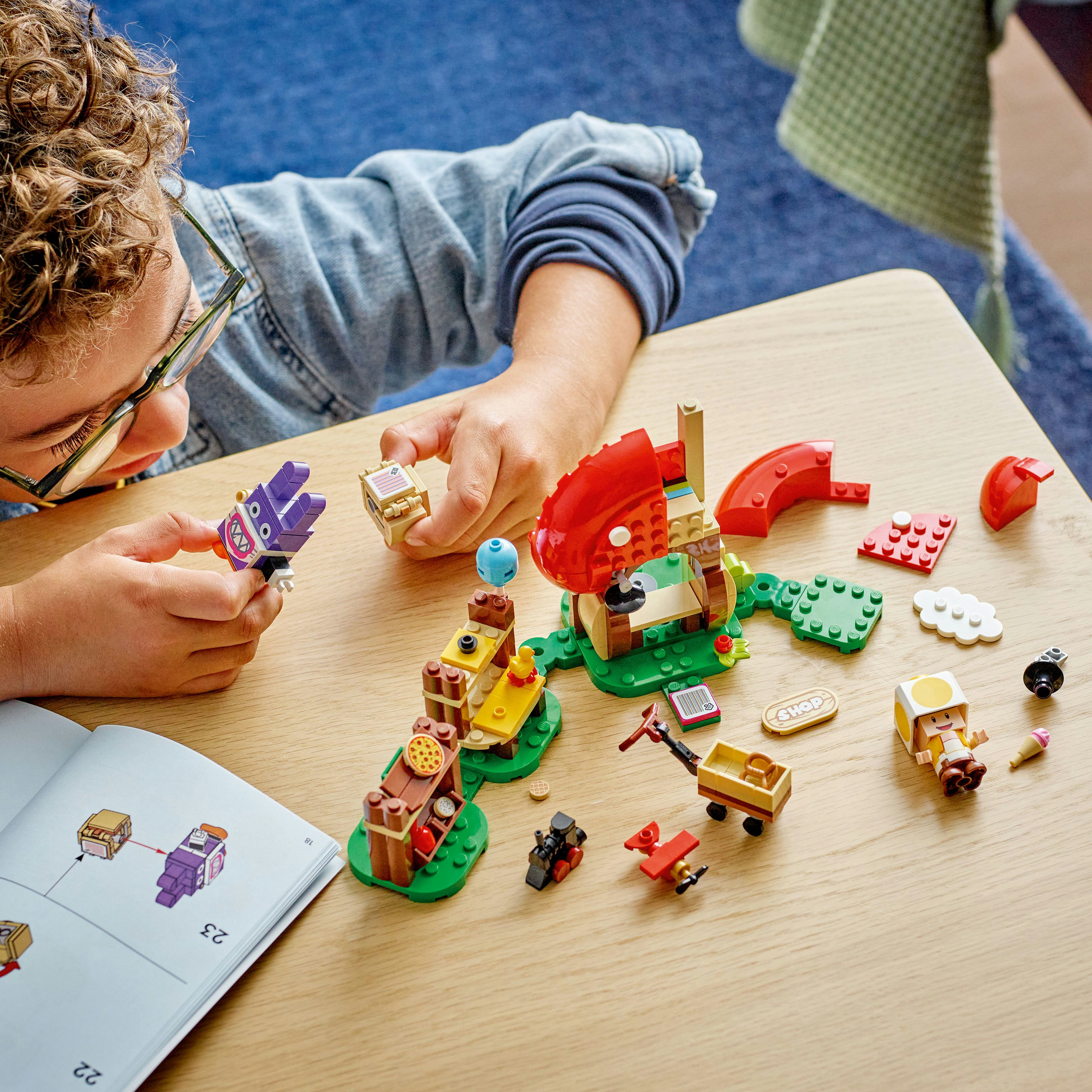 Un bambino costruisce strutture Lego, concentrandosi su un edificio con un fungo.