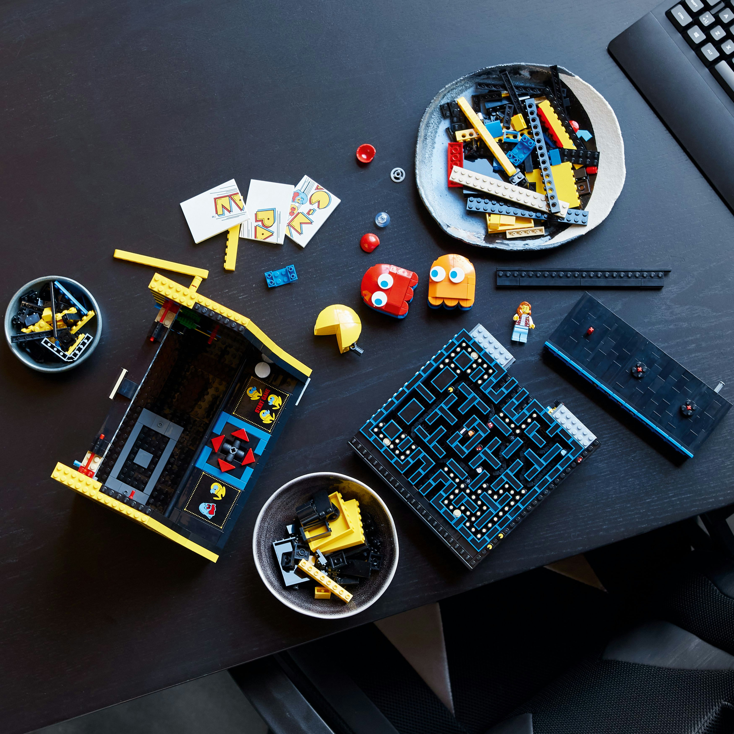 Lego Pac-Man Set, einschließlich Spielelementen und einem schwarzen Tisch.