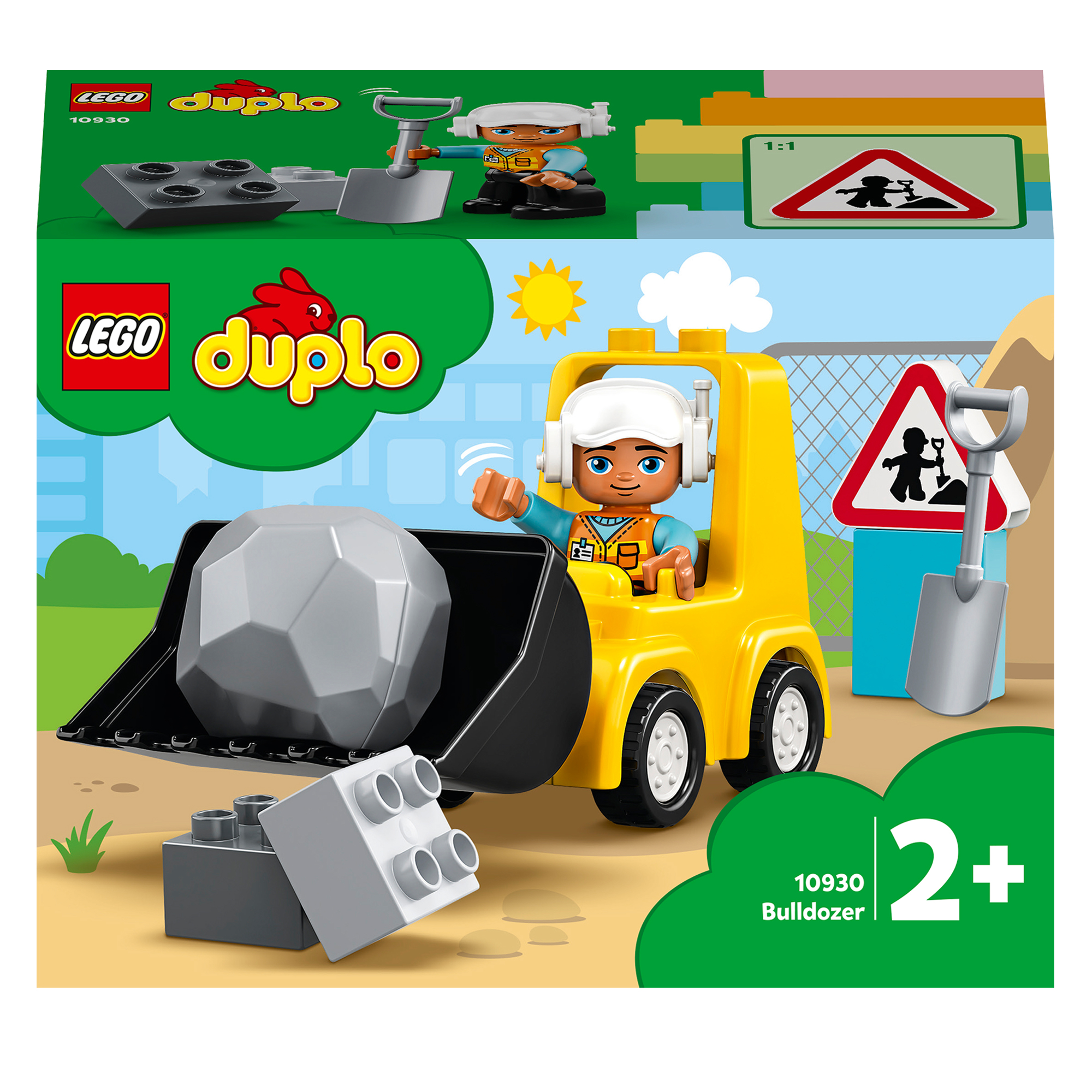 Un bulldozer LEGO giallo con una figura sta spingendo una roccia grigia. Un cartello e una scatola Lego sullo sfondo.