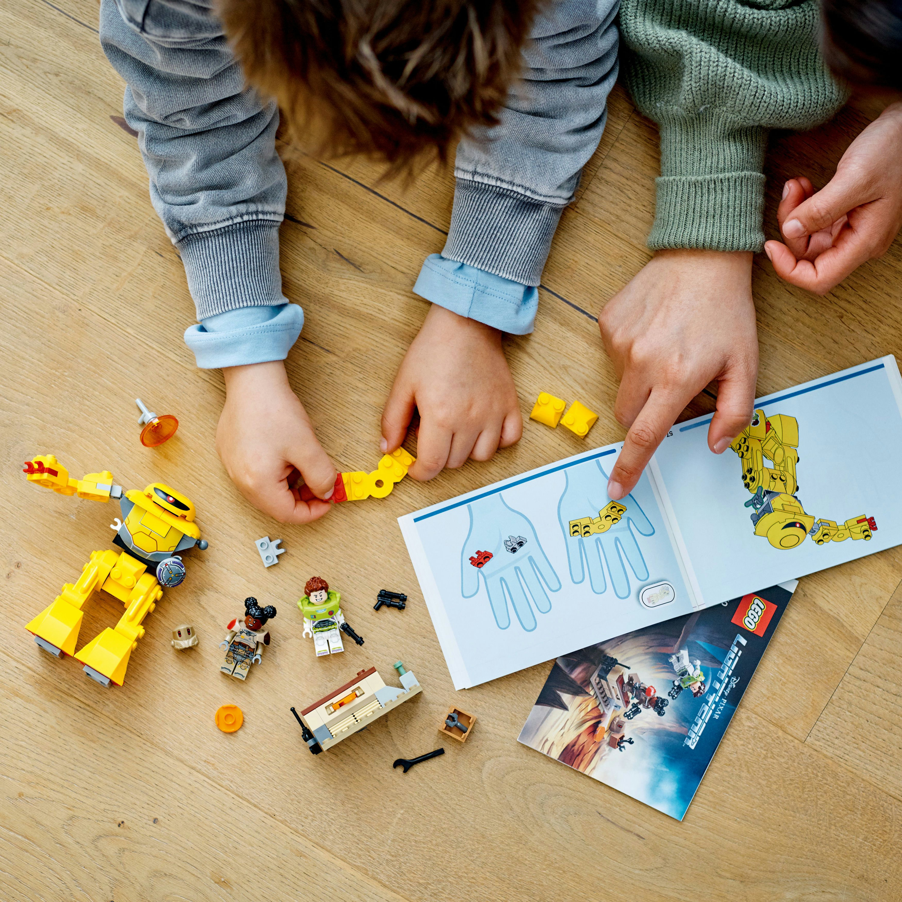 Kinder bauen Lego-Set mit Anweisungen und verschiedenen Lego-Teilen.