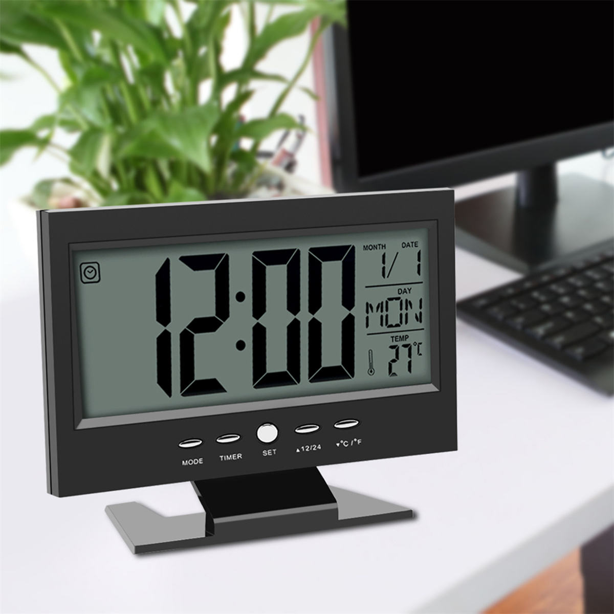 Eine schwarze Digitaluhr, die 12:00 anzeigt, mit weißem Hintergrund.
