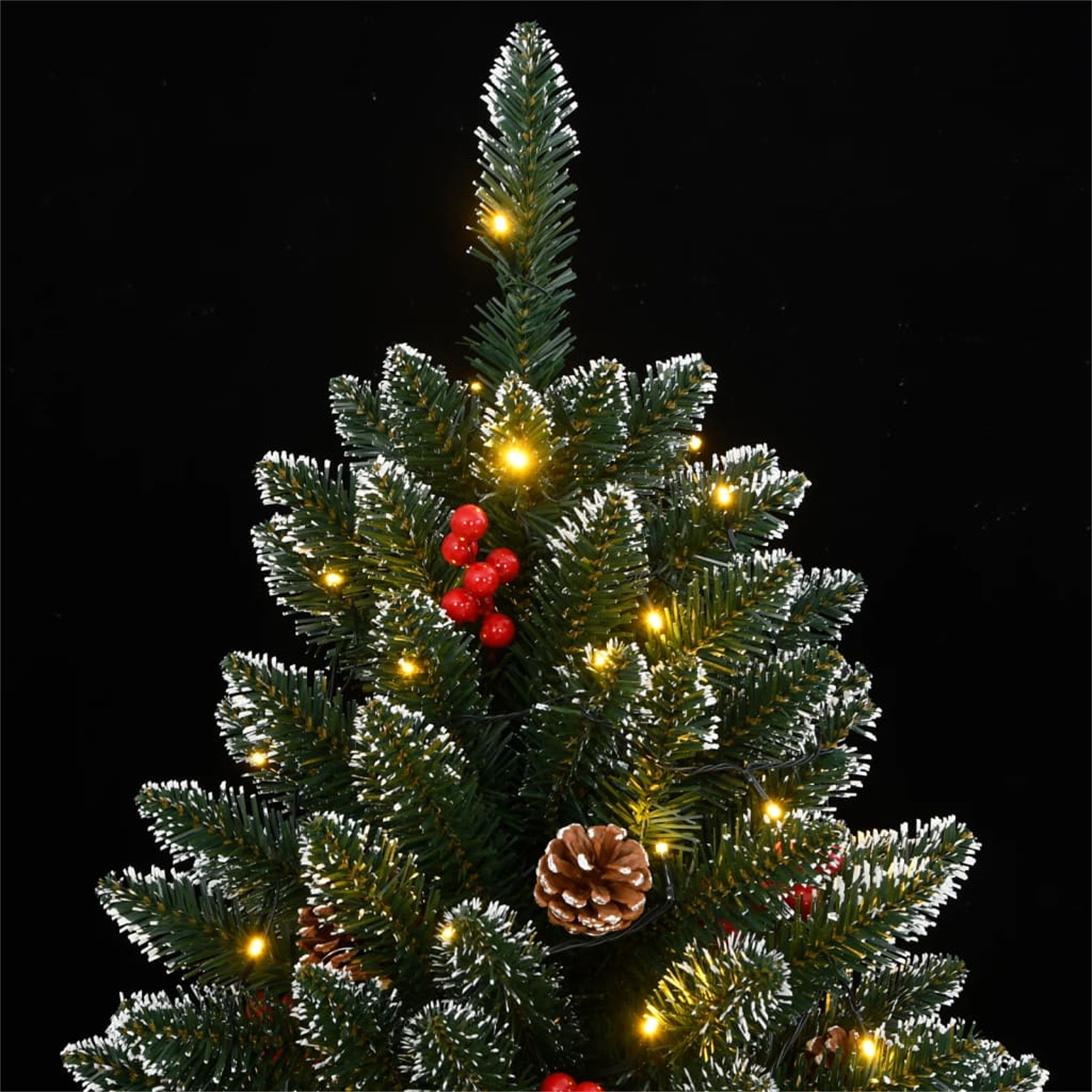 Dekorierte Weihnachtsbaumspitze mit Lichtern, roten Beeren und Tannenzapfen vor schwarzem Hintergrund.