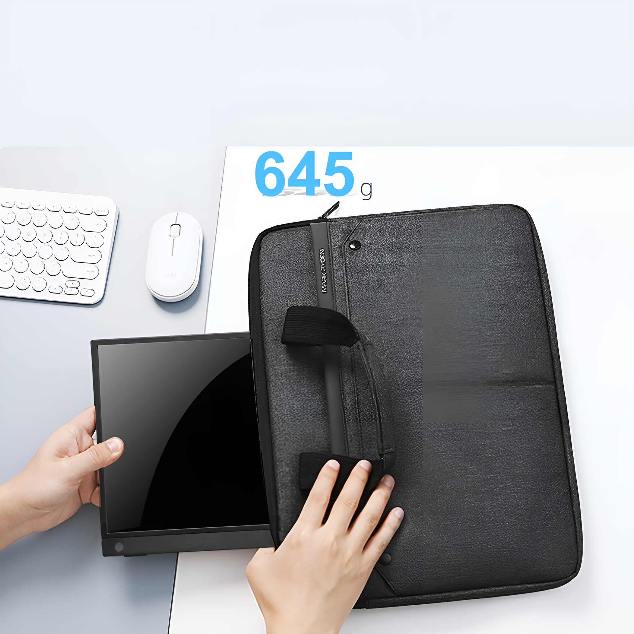 Schwarze Laptoptasche, Monitor in den Händen, weiße Maus auf grauer Oberfläche.