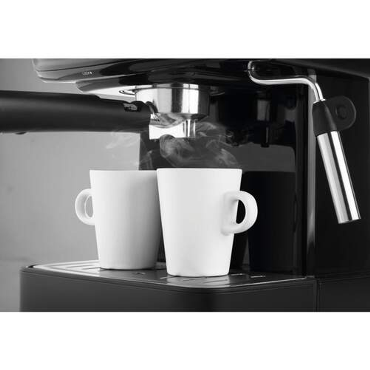 Cafetera espresso con dos tazas blancas y vapor ascendente.