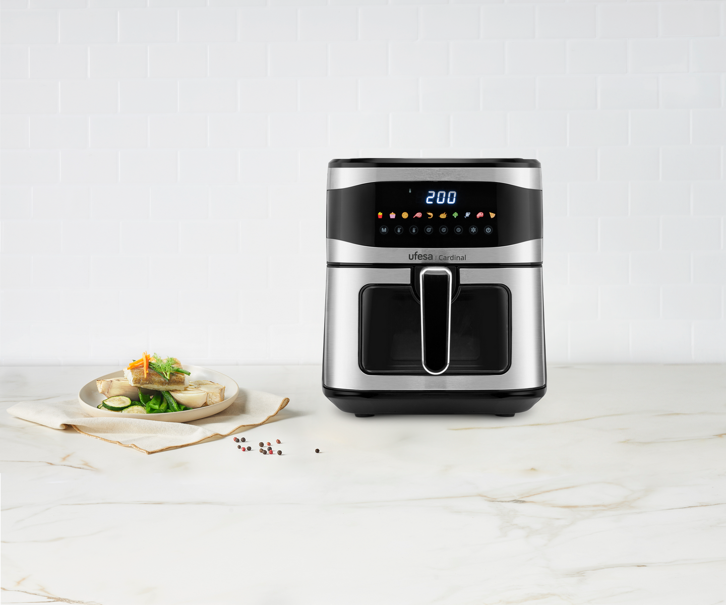 Srebrno-czarna frytkownica beztłuszczowa z wyświetlaczem. Na pierwszym planie talerz z jedzeniem.