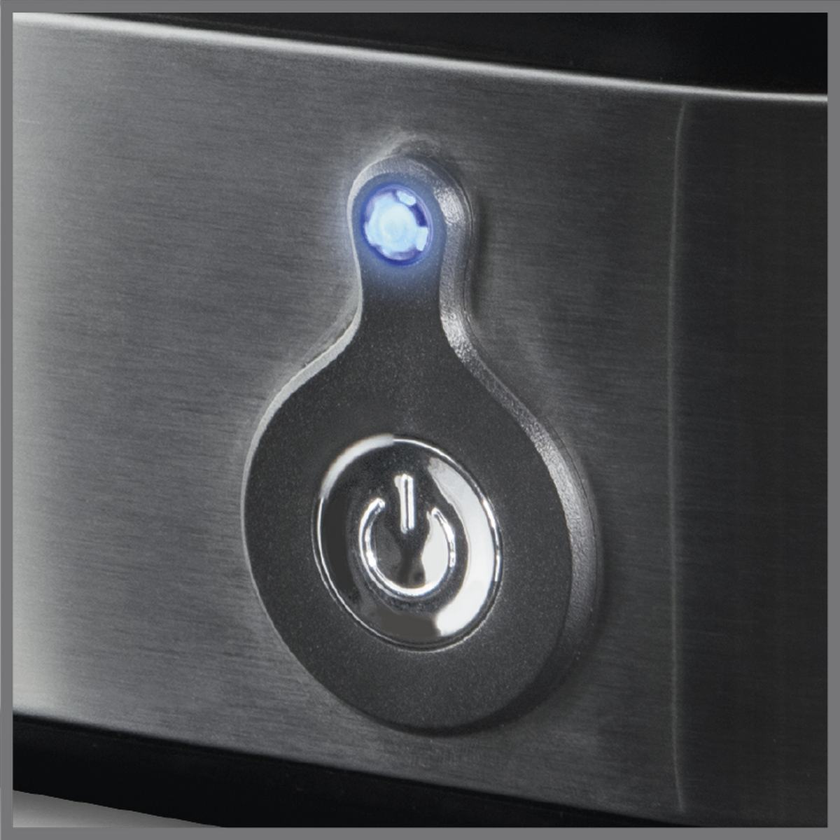 Nahaufnahme eines Einschaltknopfs auf einer gebürsteten Metalloberfläche mit blauem Licht.