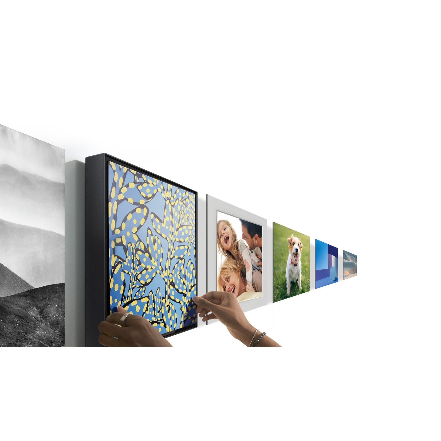 Ręce wieszają zdjęcia na ścianie. Nowoczesne mieszkanie z różnymi zdjęciami i dziełami sztuki.