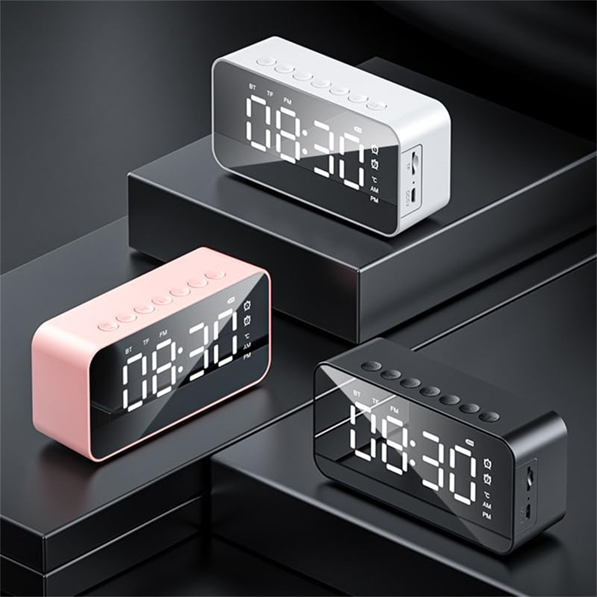 Drei Digitaluhren mit großen Displays. Eine rosa, eine weiße und eine schwarze auf schwarzen Plattformen.
