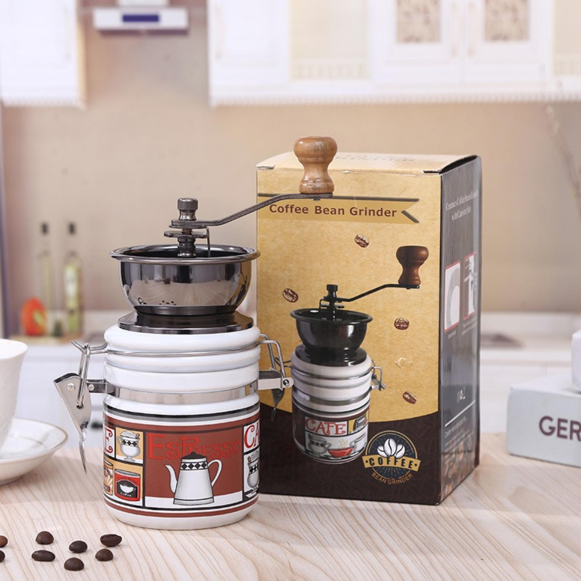 Kaffeebohnenmühle mit Karton, die die Mühle und Kaffeebohnen zeigt. Kaffeebohnen sind verstreut.