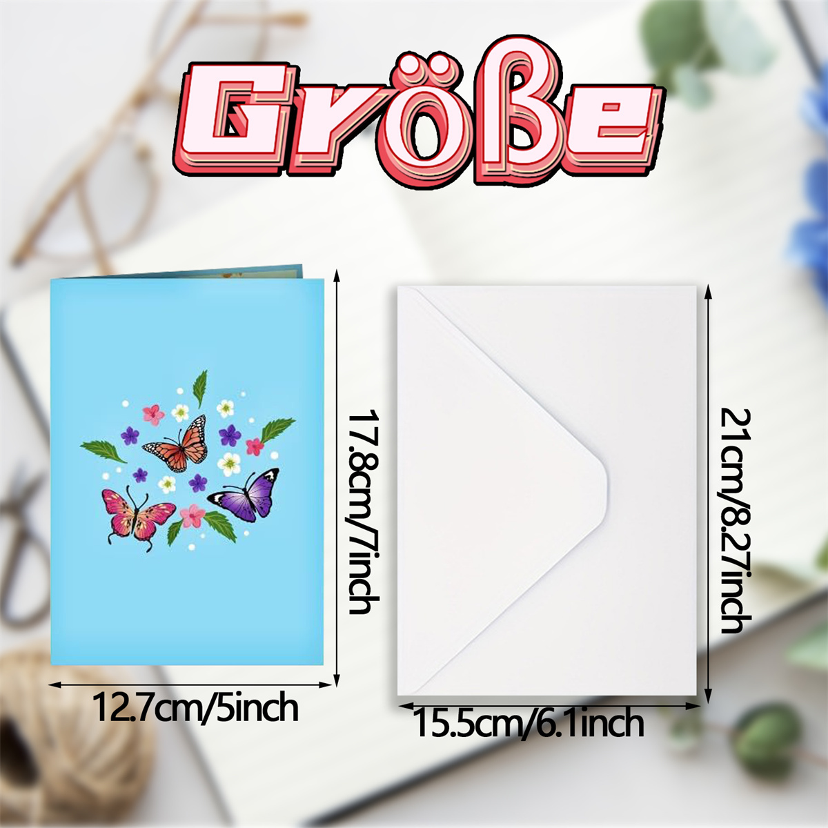 Blaue Karte mit Schmetterlingskunst neben einem weißen Umschlag. Abmessungen in cm und Zoll angegeben.