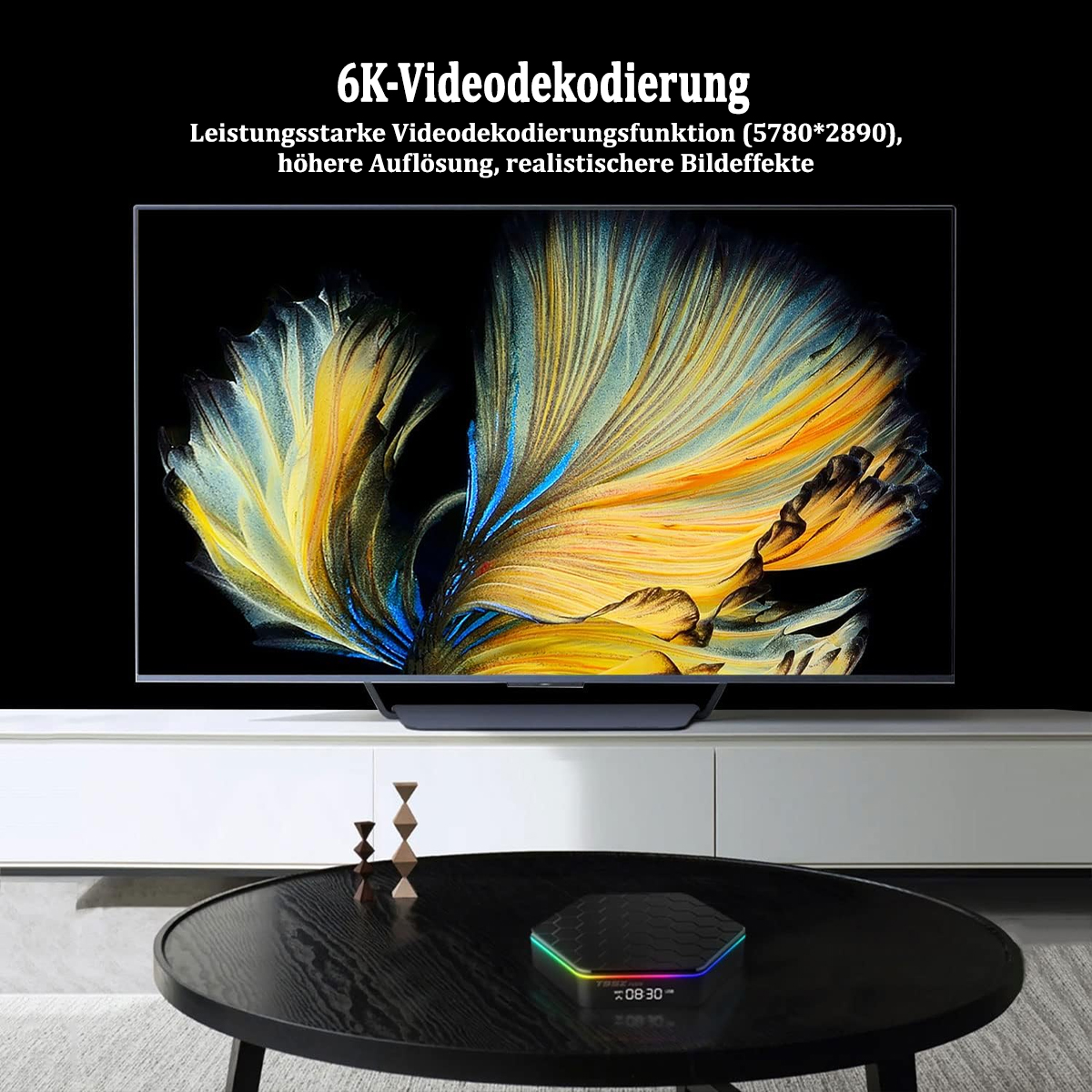 Ein großer Fernseher mit Text über 6K-Videodekodierung und ein kleines sechseckiges Gerät auf einem Tisch.