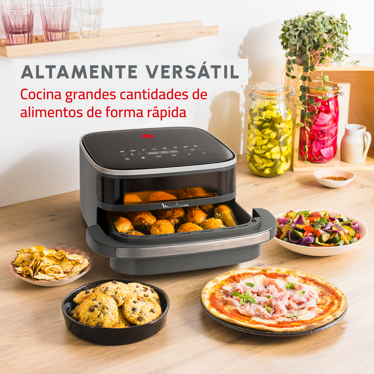 Frytkownica powietrzna z różnymi potrawami, w tym pizzą i ciasteczkami.