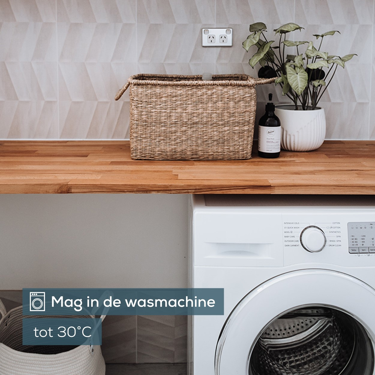Waschküche mit Waschmaschine, Korb, Pflanze und Holztresen.